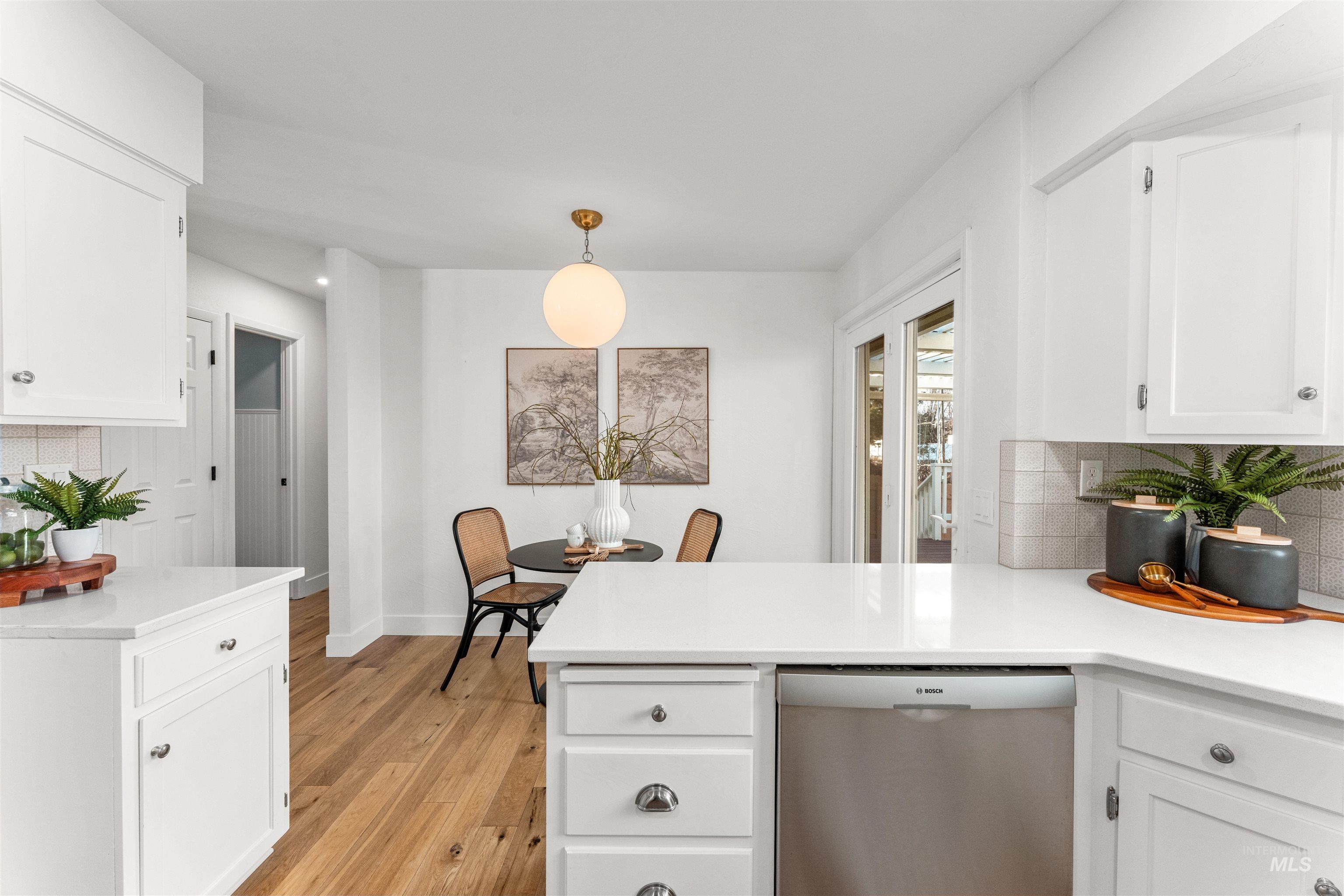 Kitchen featuring tasteful backsplash, white cabinets, stainless steel dishwasher, a peninsula, and recessed lighting