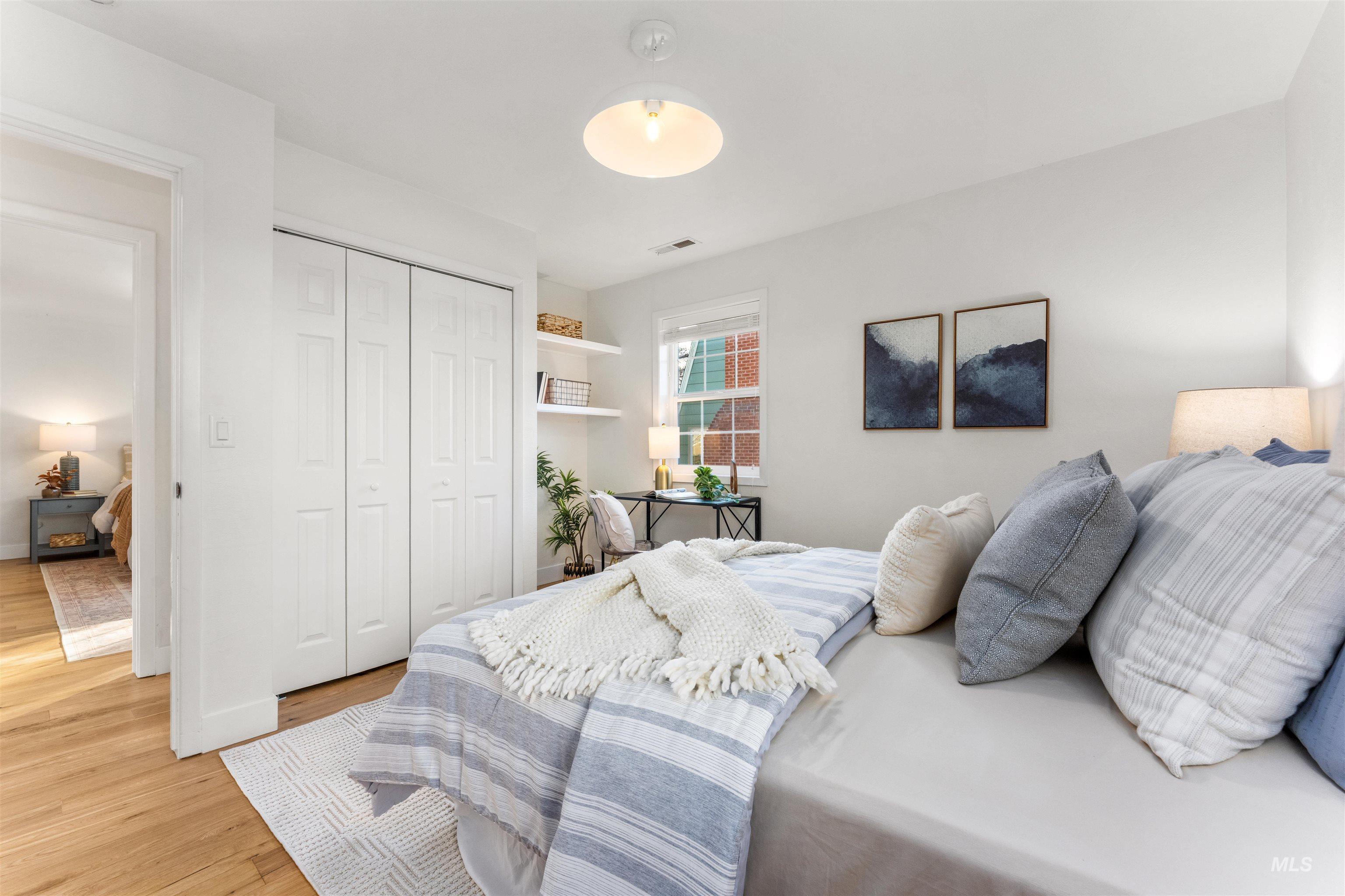 Bedroom with light wood-style flooring and a closet