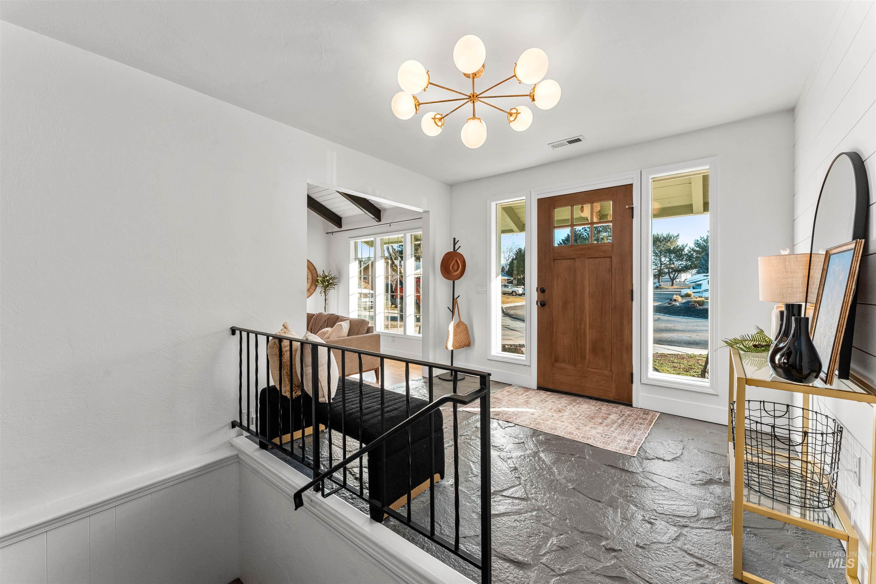 Foyer featuring a chandelier and wainscoting