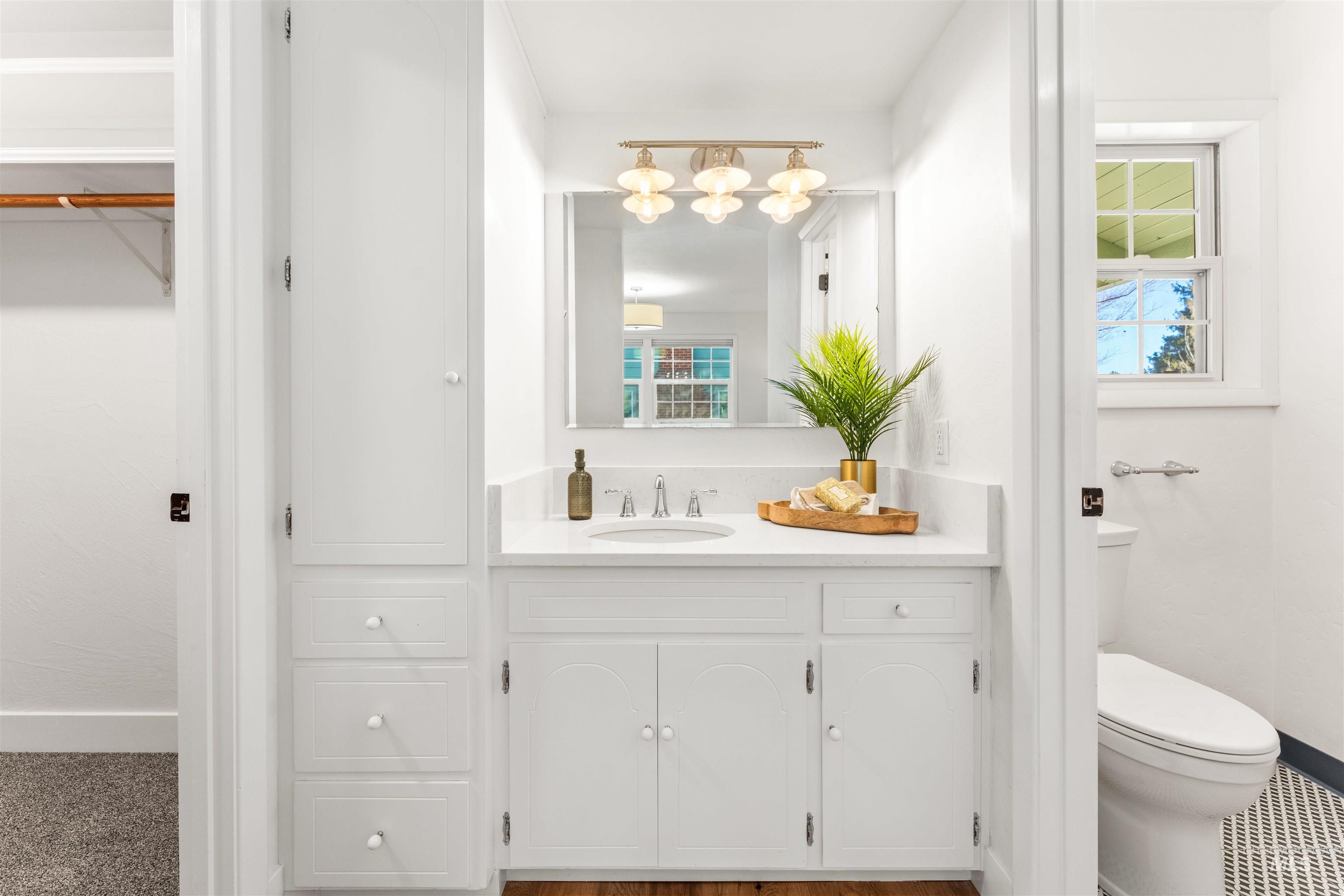Full bathroom with vanity and a spacious closet