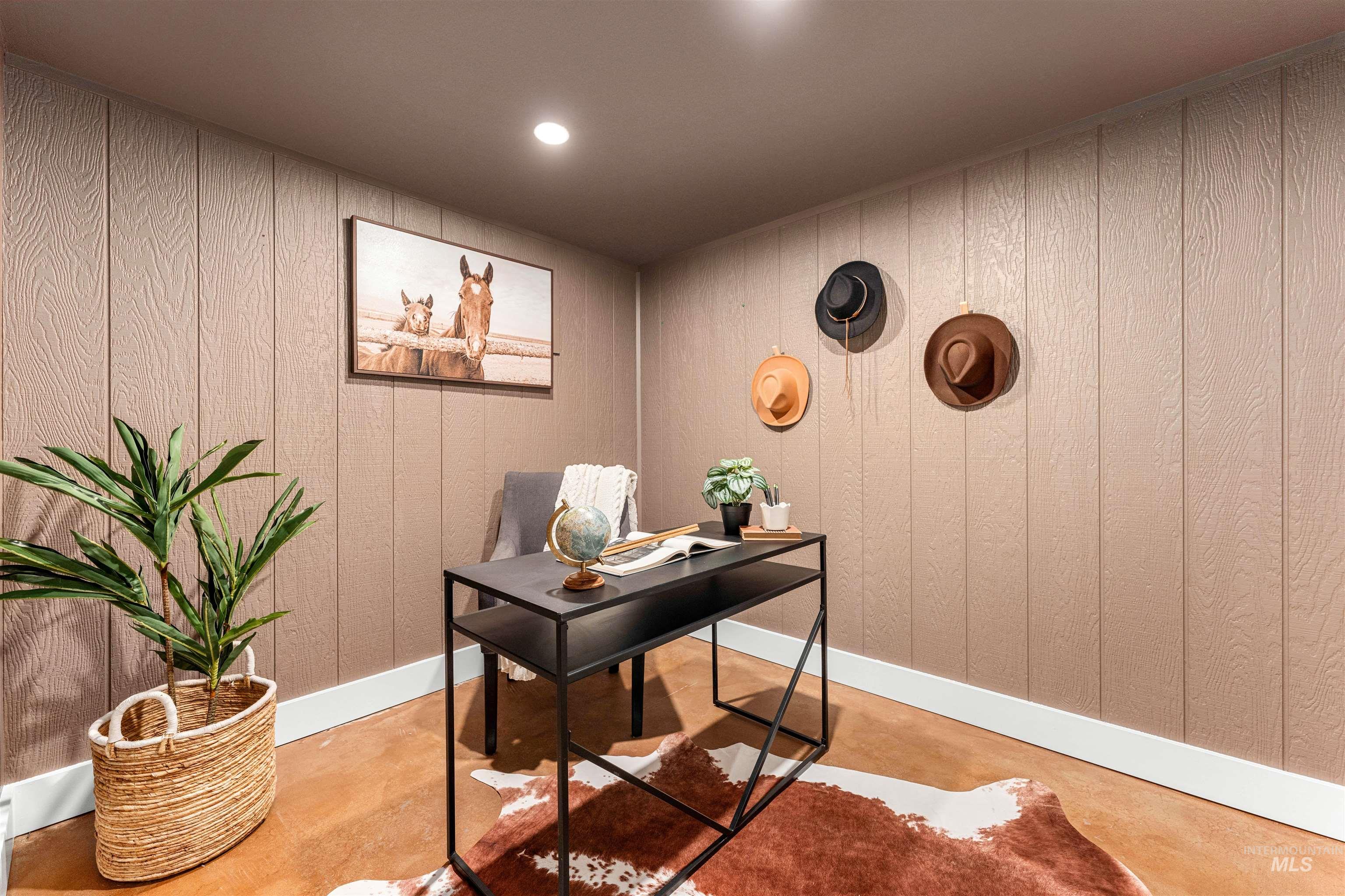 Home office featuring concrete flooring, recessed lighting, and wood walls