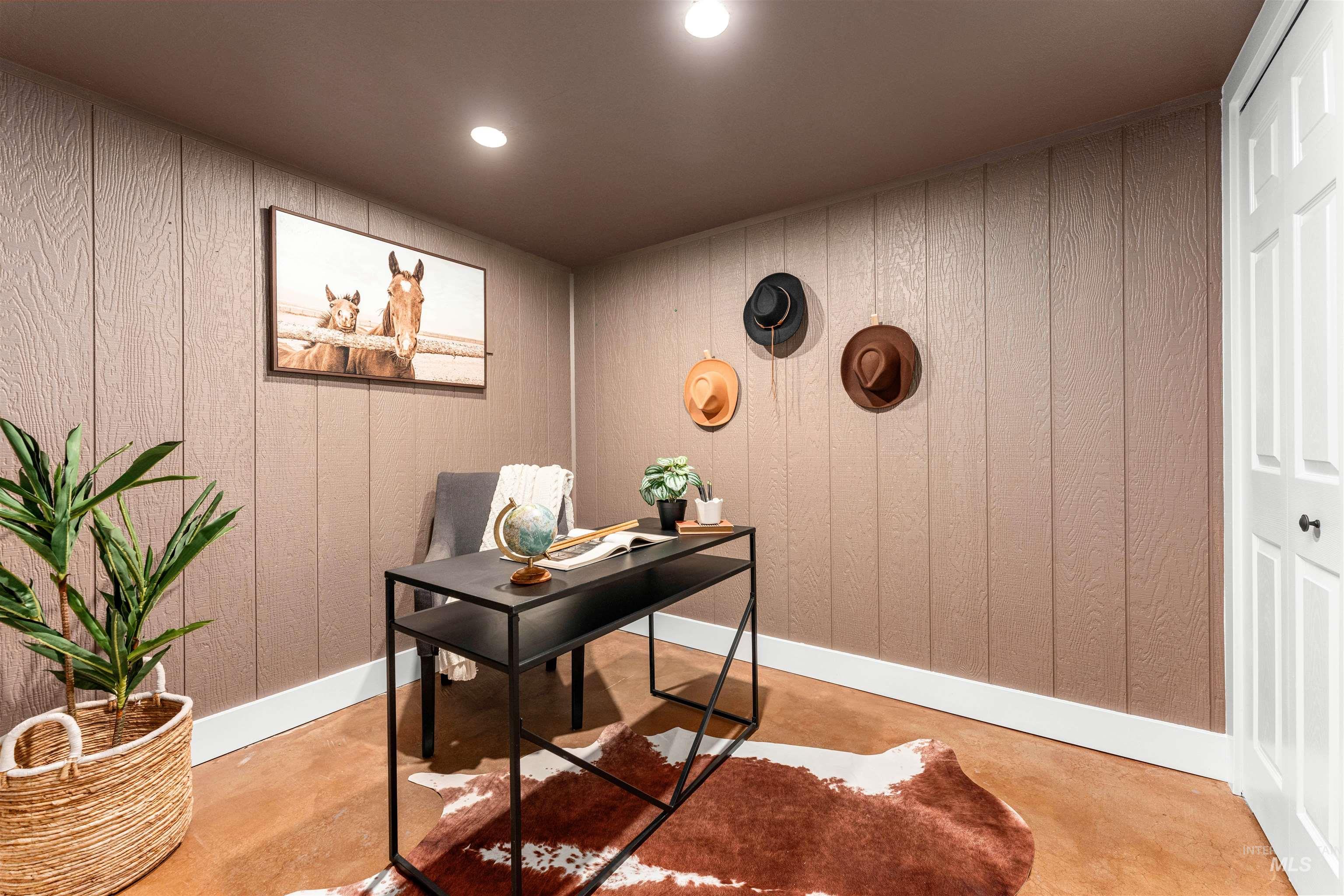 Office space with finished concrete flooring, recessed lighting, and wood walls