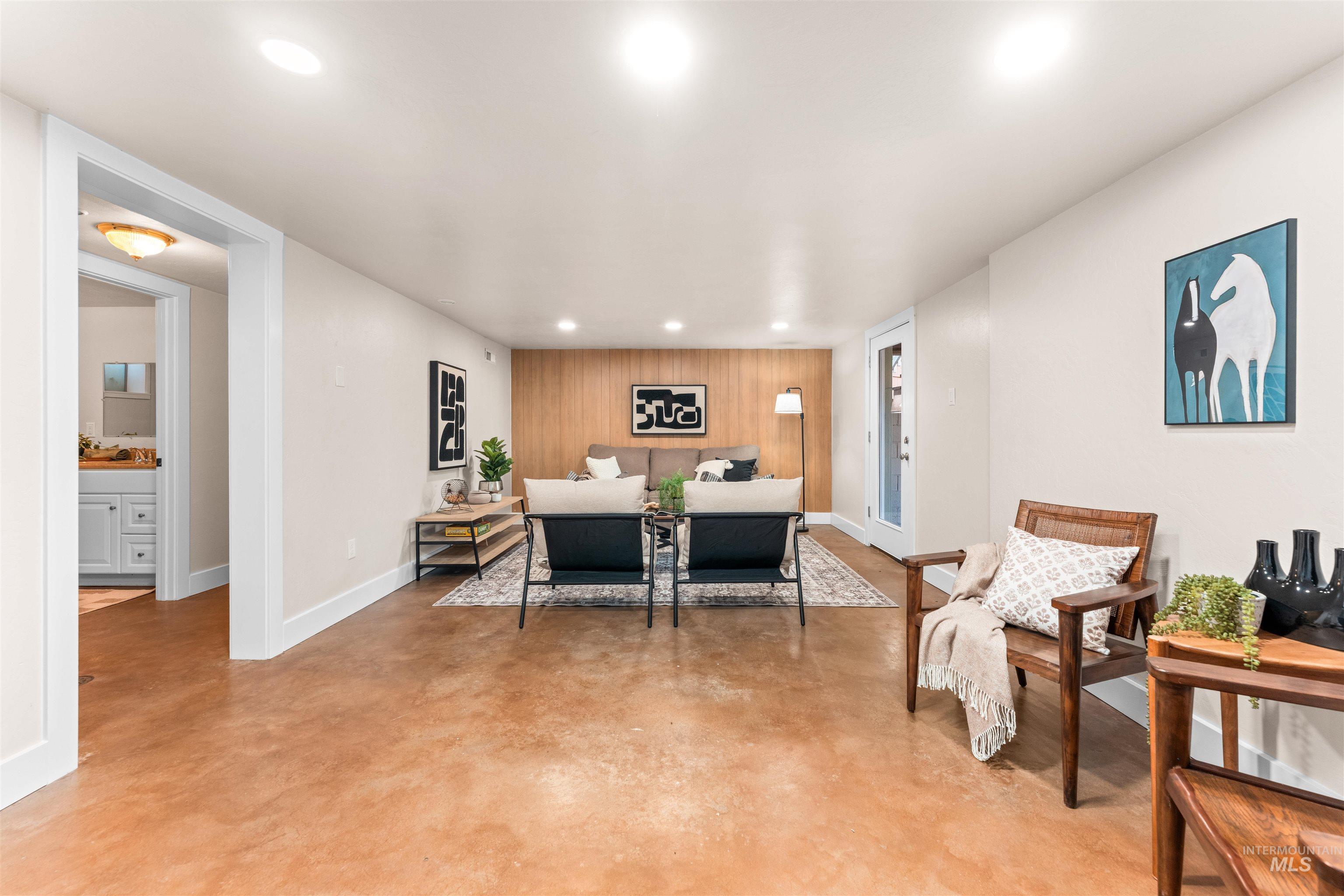 Dining area featuring finished concrete flooring, wood walls, an accent wall, and recessed lighting