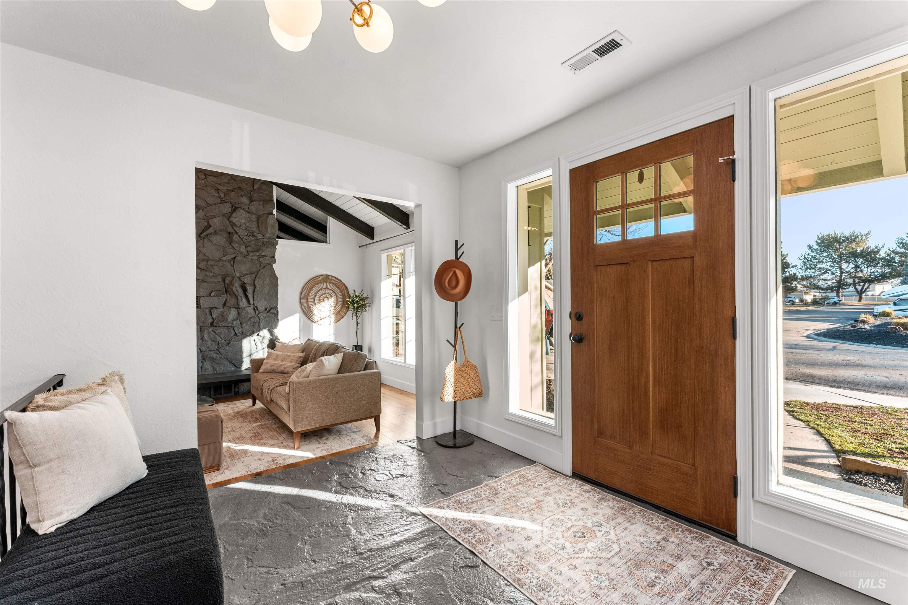 Foyer entrance featuring beam ceiling and baseboards