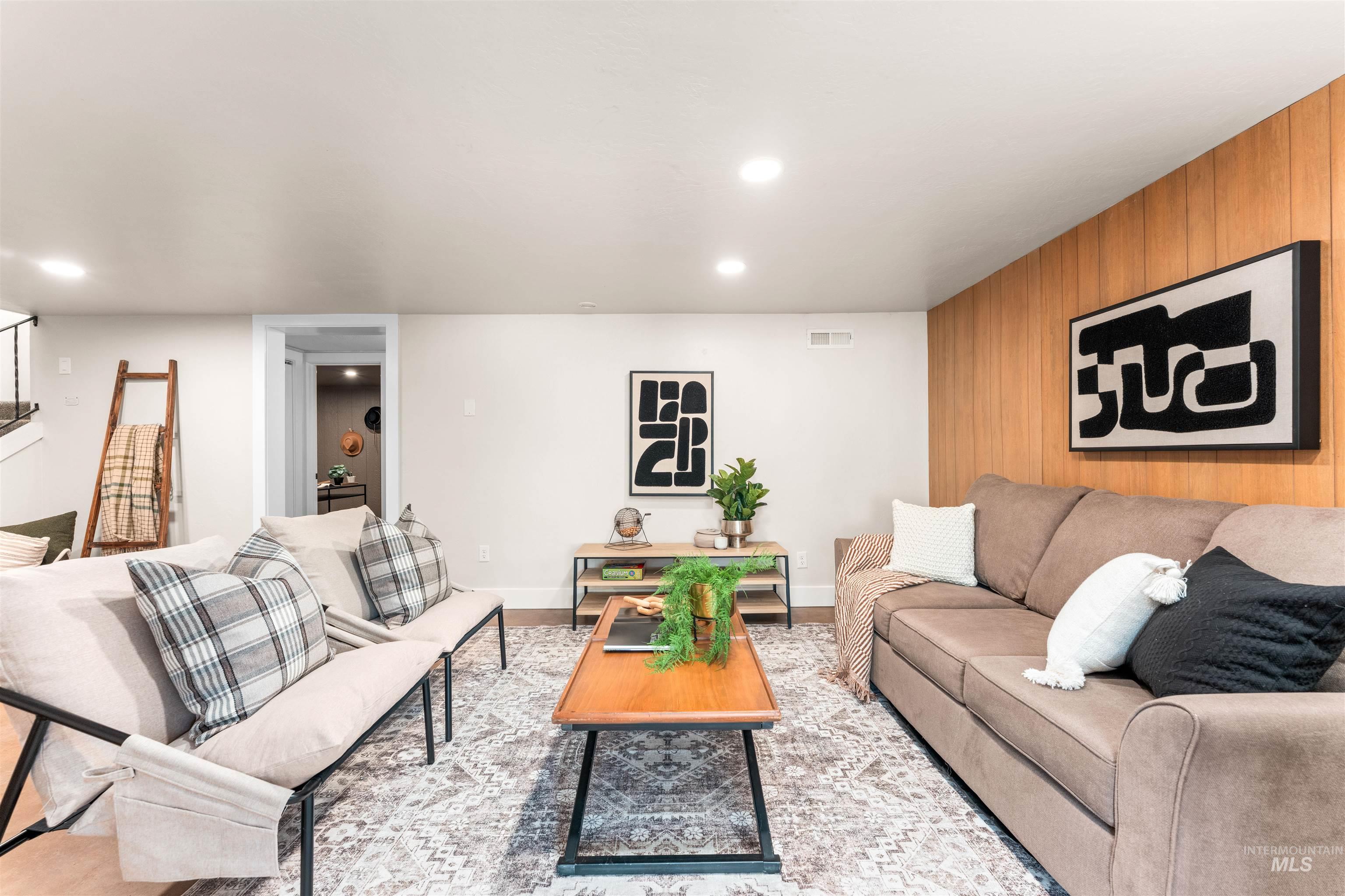 Living room with wood walls, an accent wall, and recessed lighting