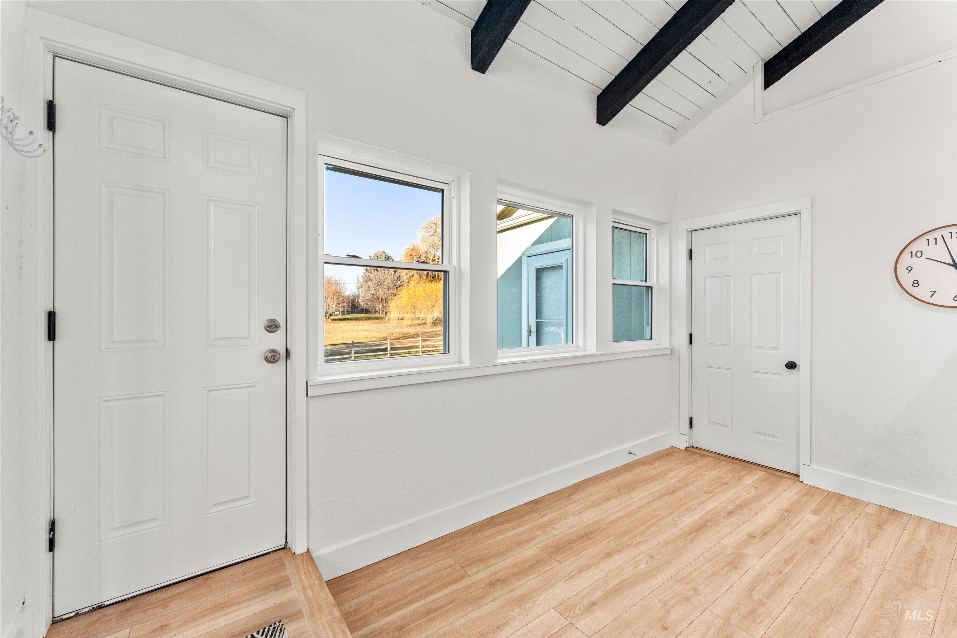 Foyer with light wood-style floors and wood ceiling