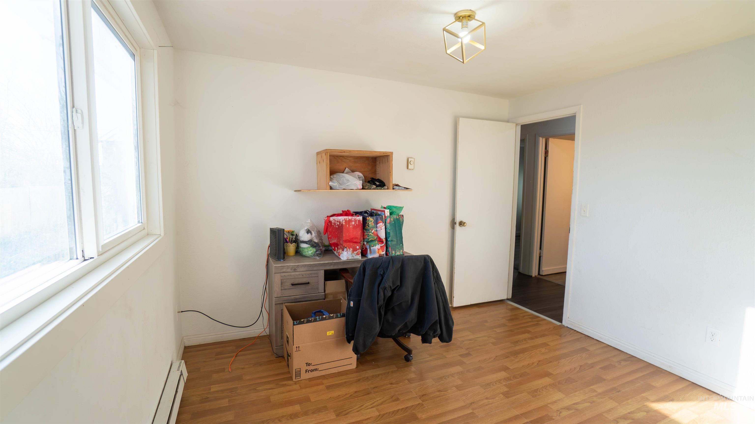 Office featuring light wood-style flooring and a baseboard radiator