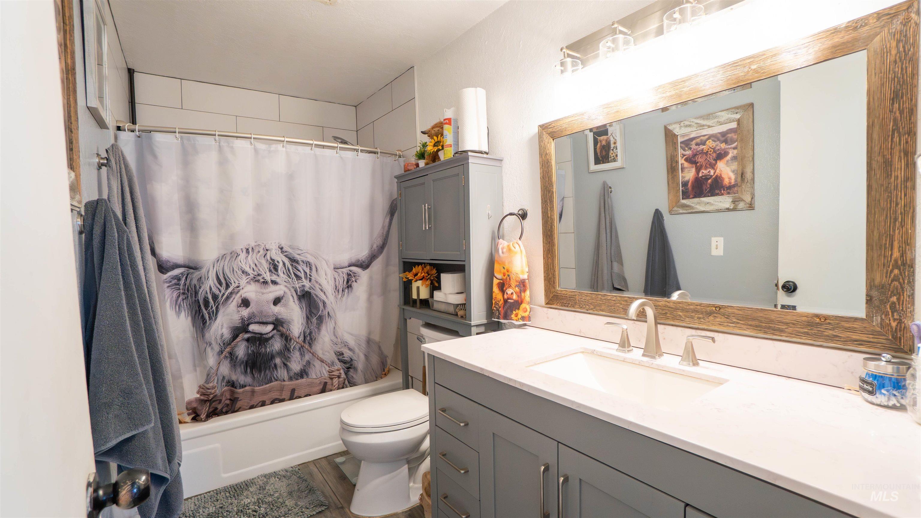Full bath featuring shower / tub combo and vanity