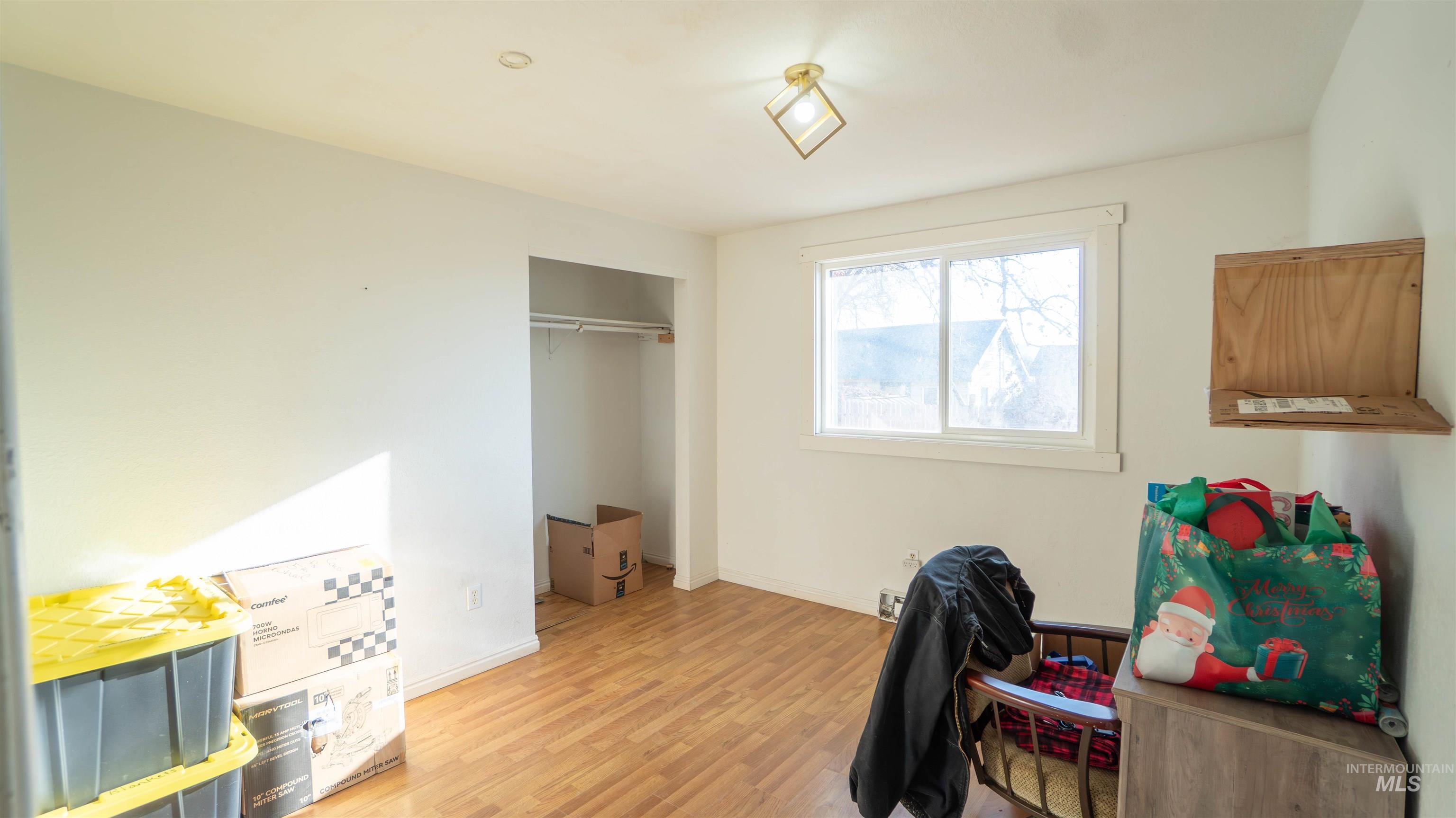Bedroom featuring wood finished floors and a closet
