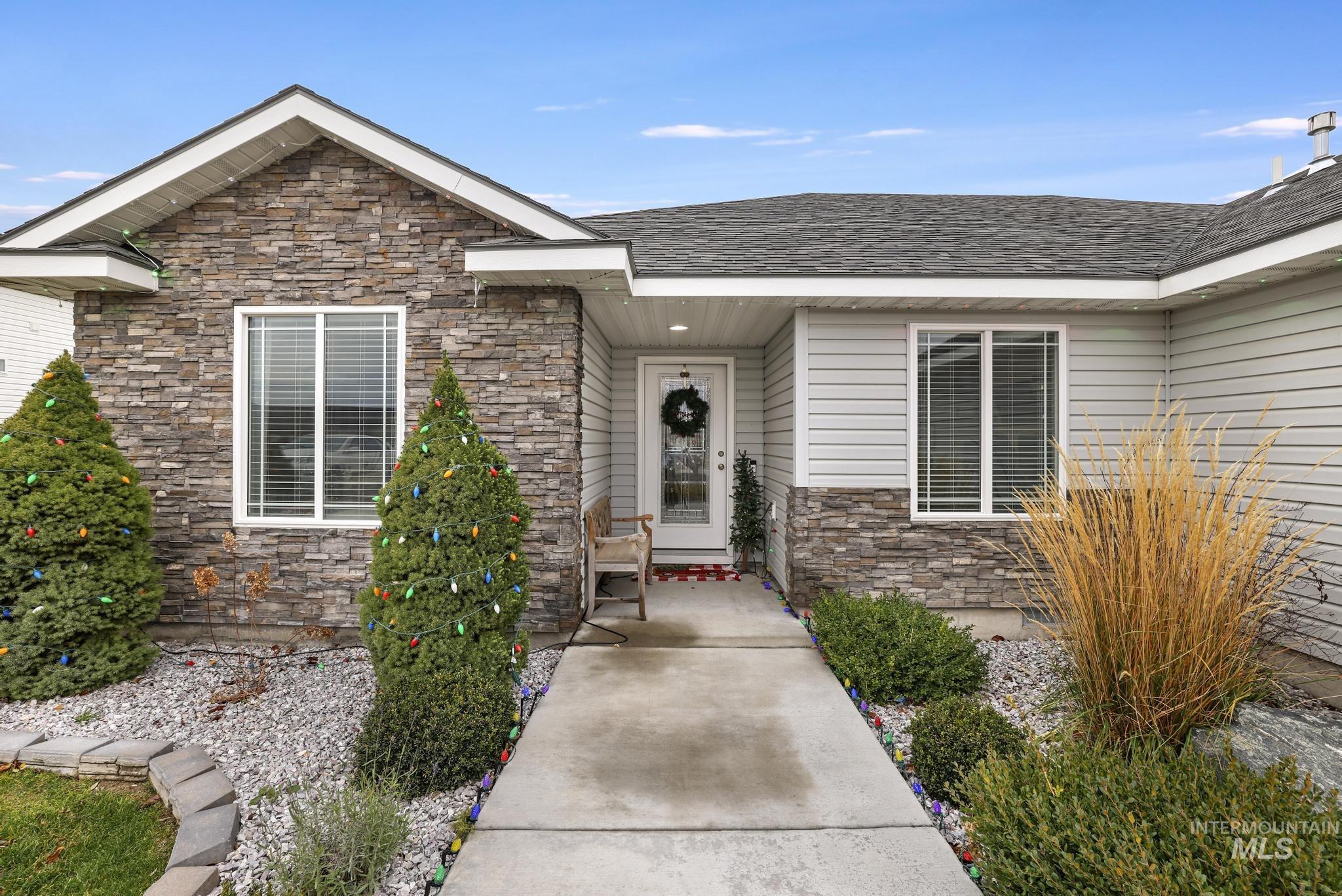 Doorway to property with stone siding and roof with shingles