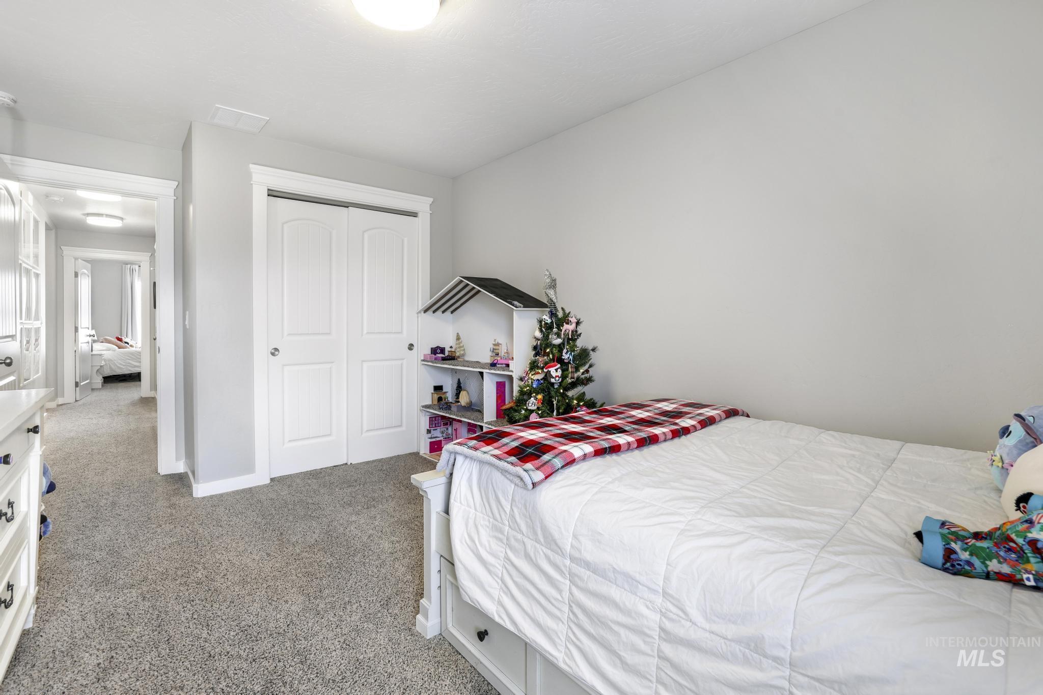 Bedroom featuring light carpet and a closet