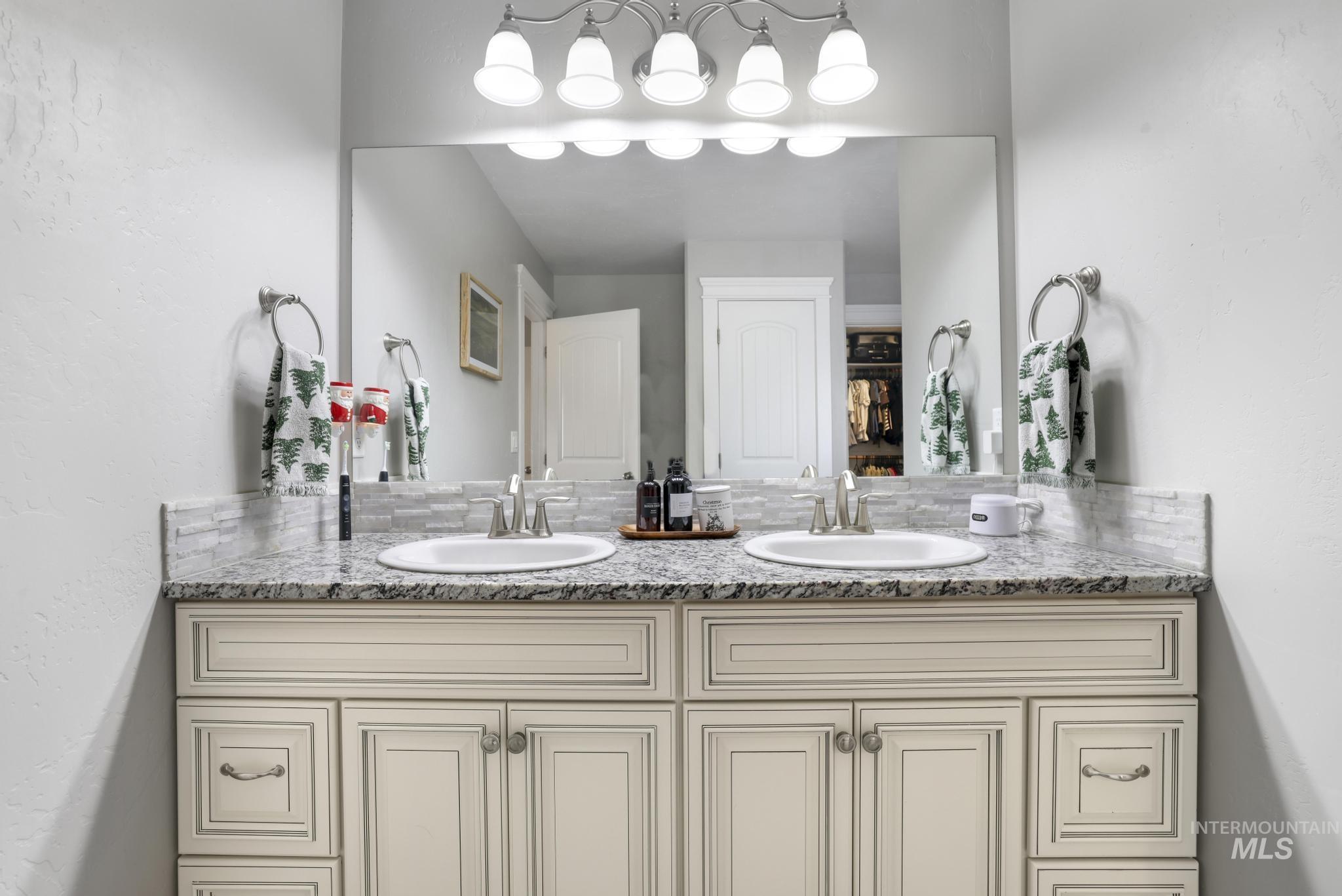 Bathroom with a textured wall and double vanity