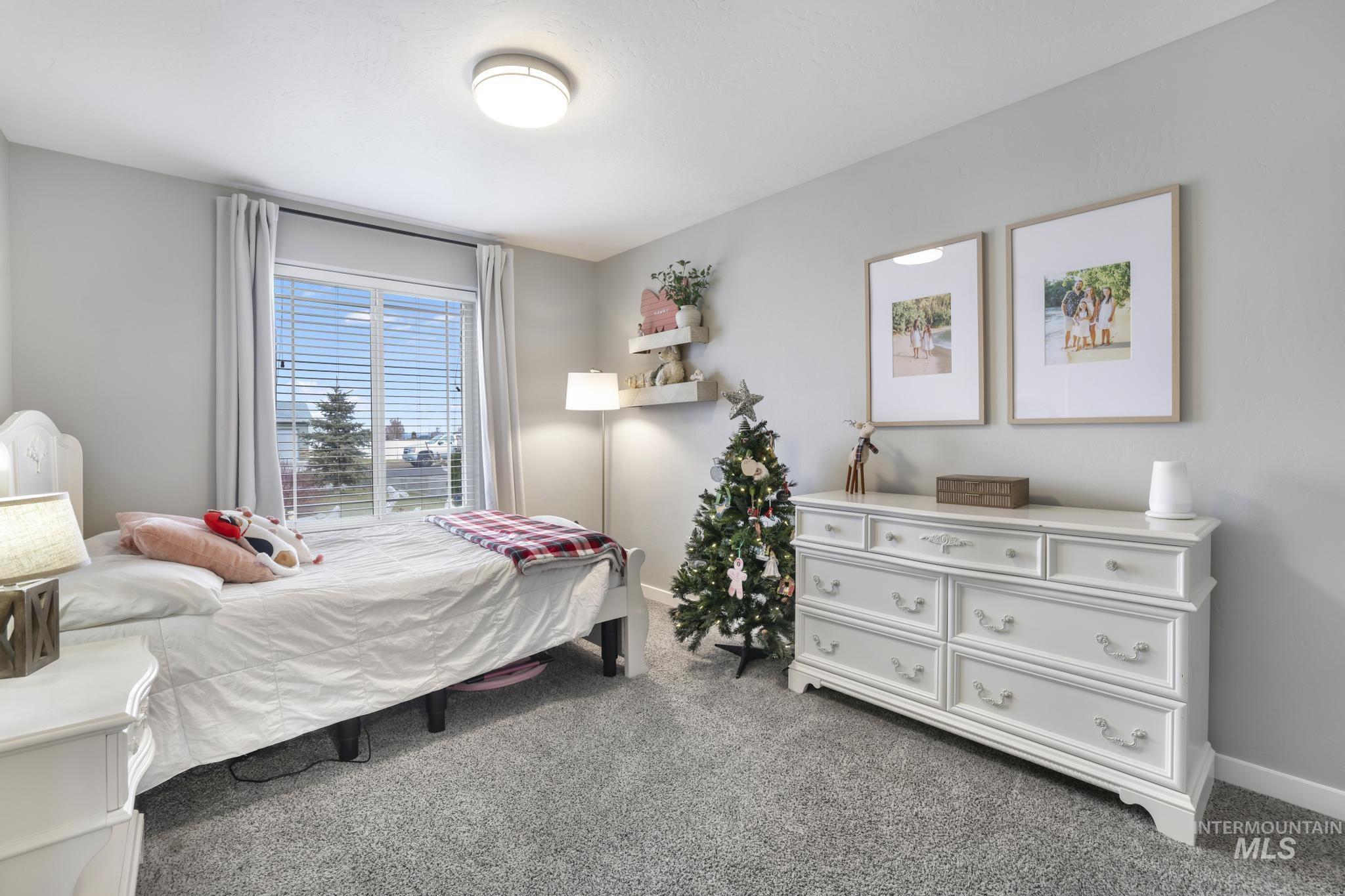 Bedroom featuring light carpet and baseboards