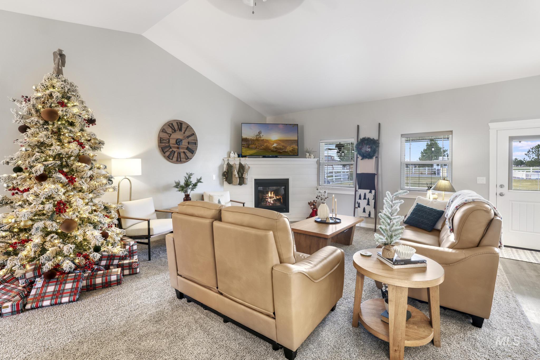 Living area featuring vaulted ceiling and a glass covered fireplace