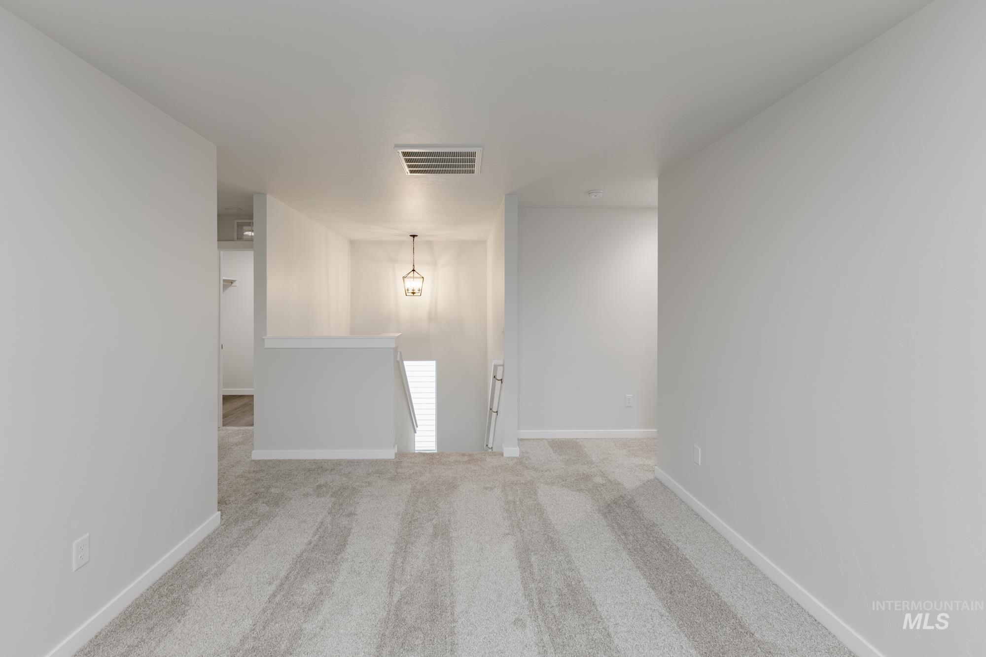 Unfurnished room featuring light colored carpet and baseboards