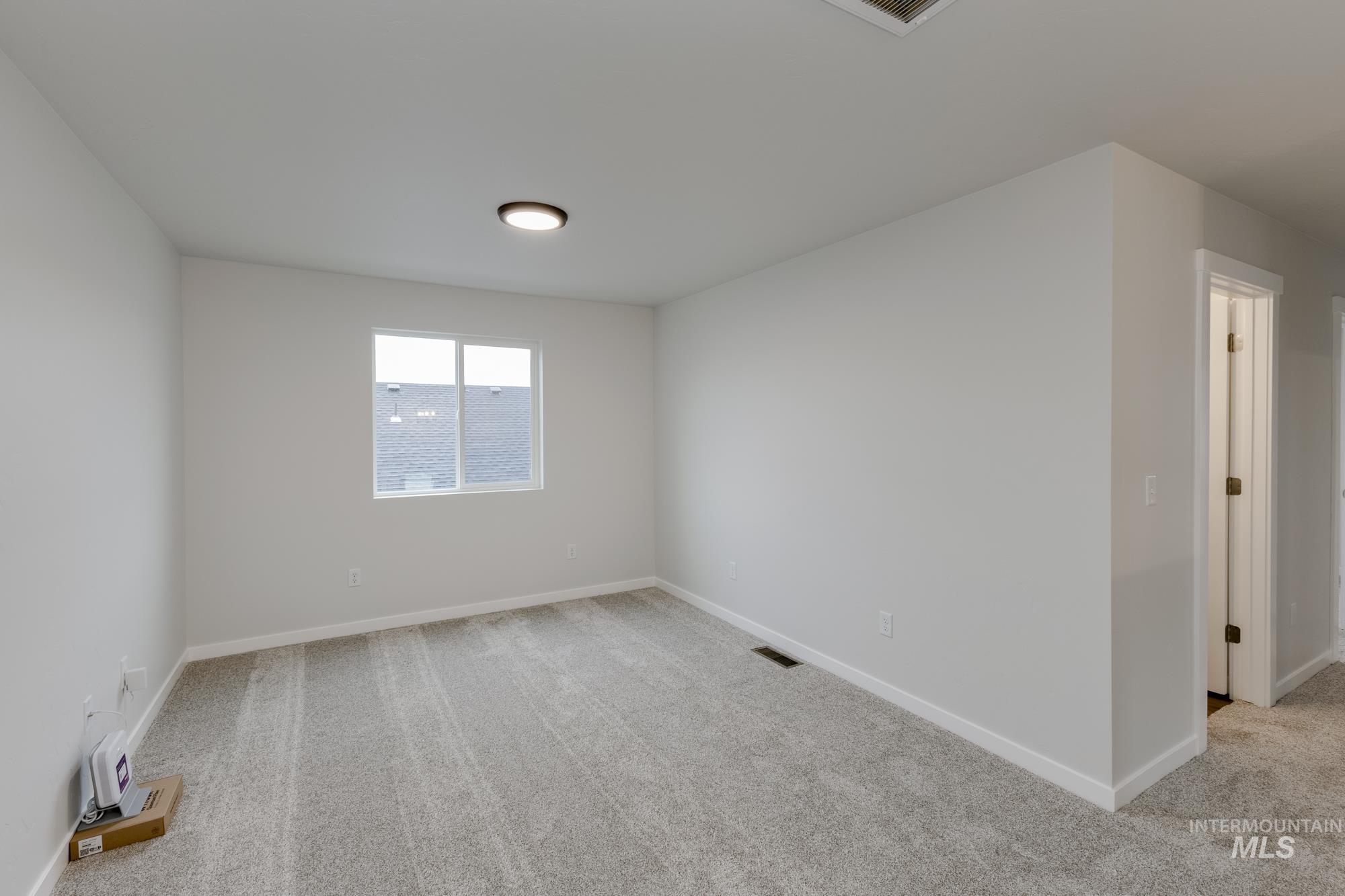 Unfurnished room featuring light carpet
