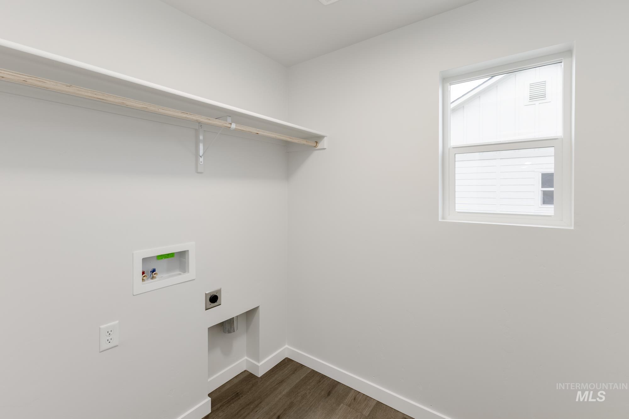 Laundry area featuring dark wood finished floors, electric dryer hookup, and washer hookup