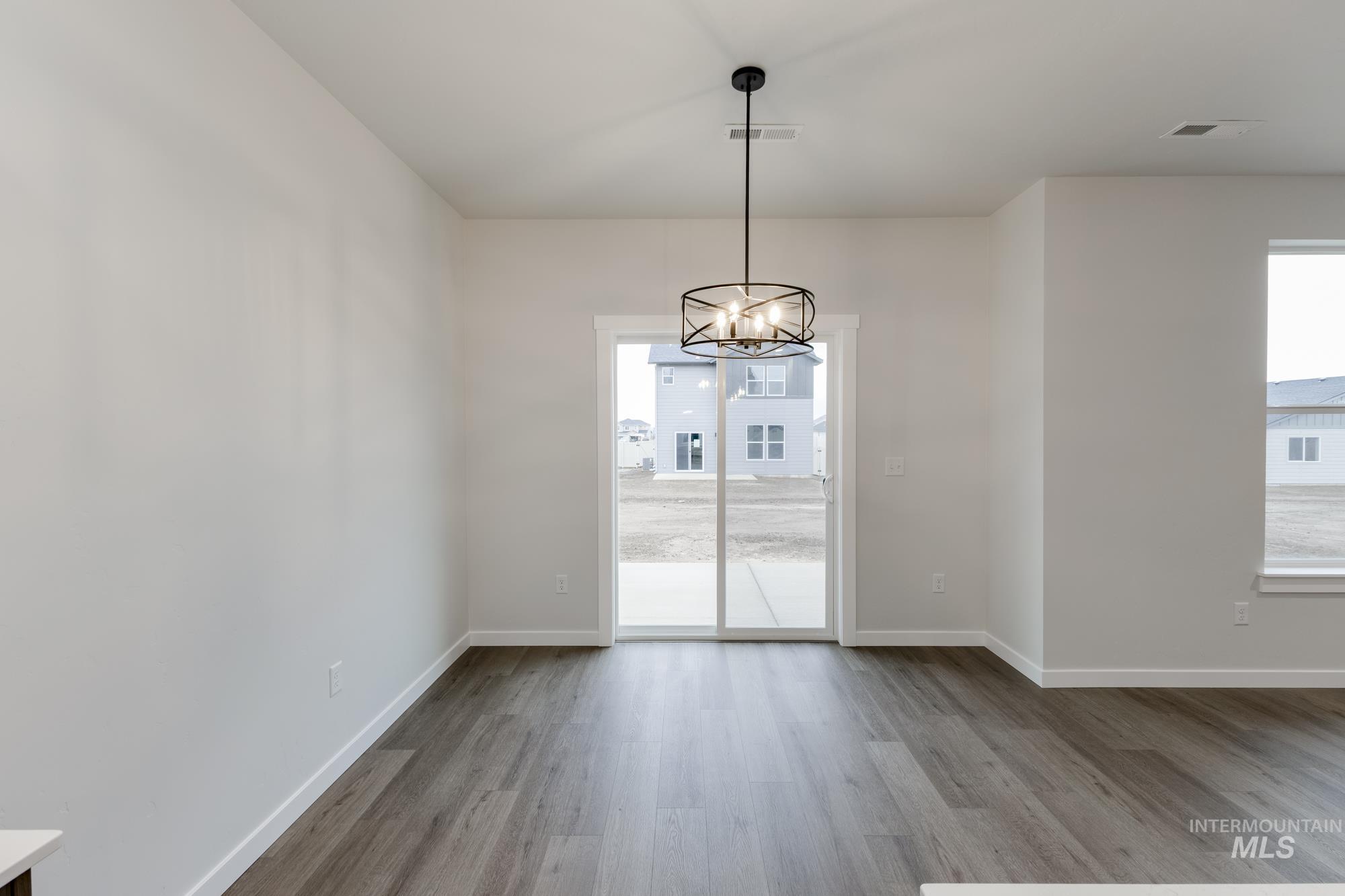 Unfurnished dining area with light wood-style flooring, a chandelier, and plenty of natural light