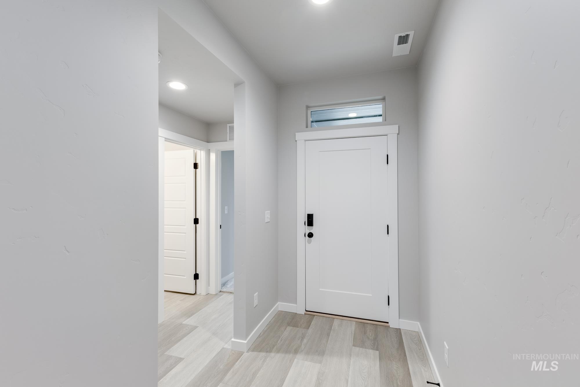 Entryway with light wood-style floors and baseboards