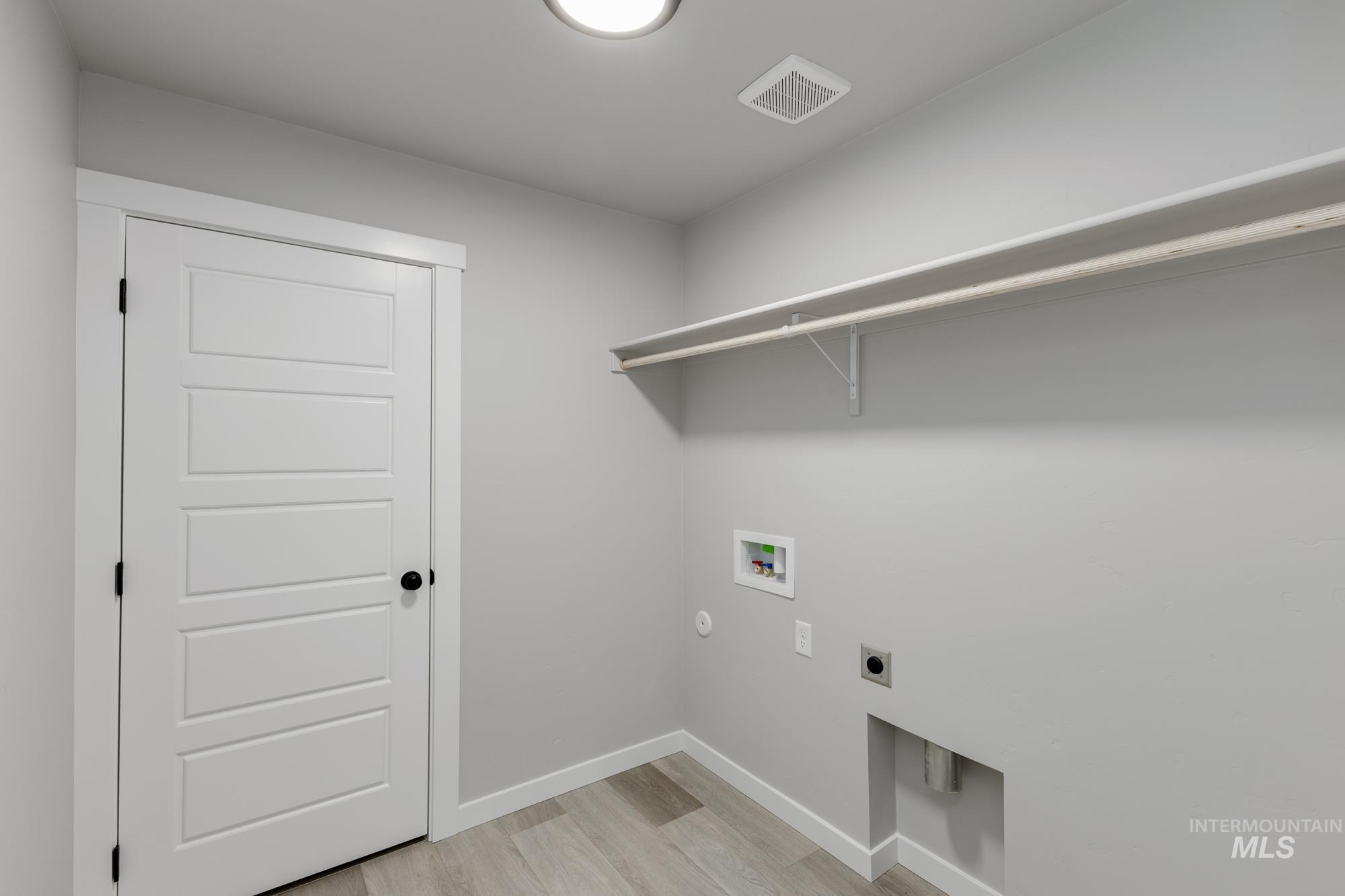 Laundry area with washer hookup, light wood finished floors, hookup for an electric dryer, and gas dryer hookup