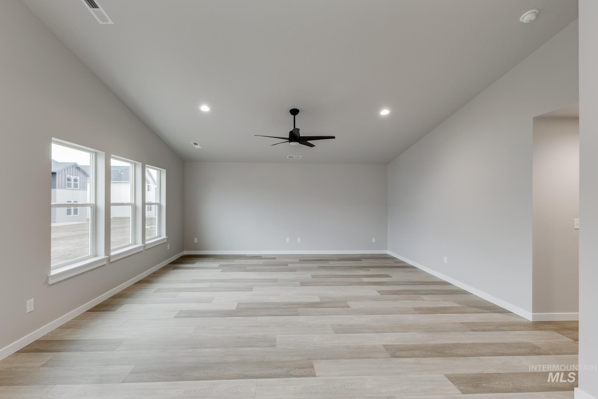 Empty room featuring recessed lighting, light wood-style floors, vaulted ceiling, and a ceiling fan