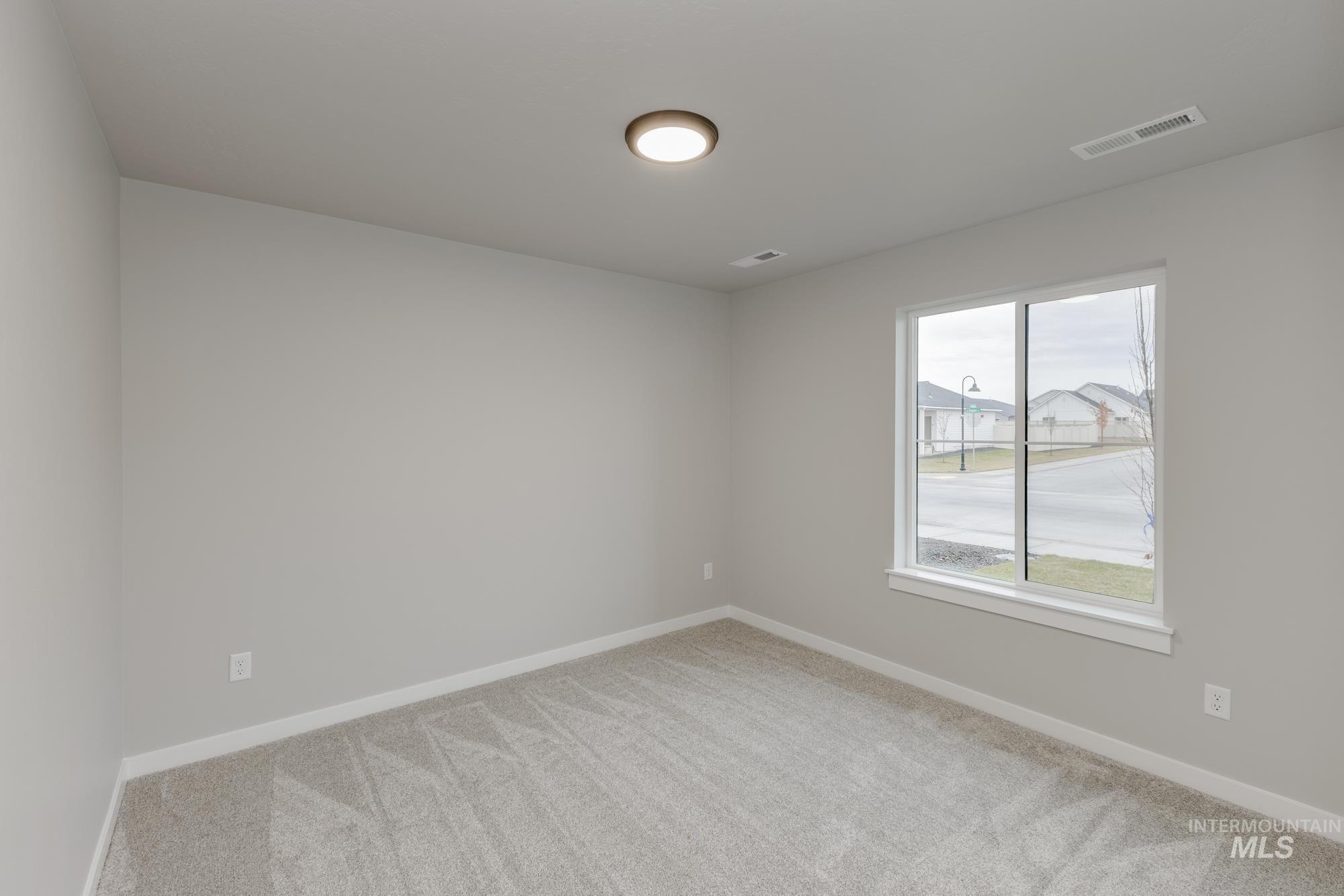 Spare room featuring baseboards and light carpet