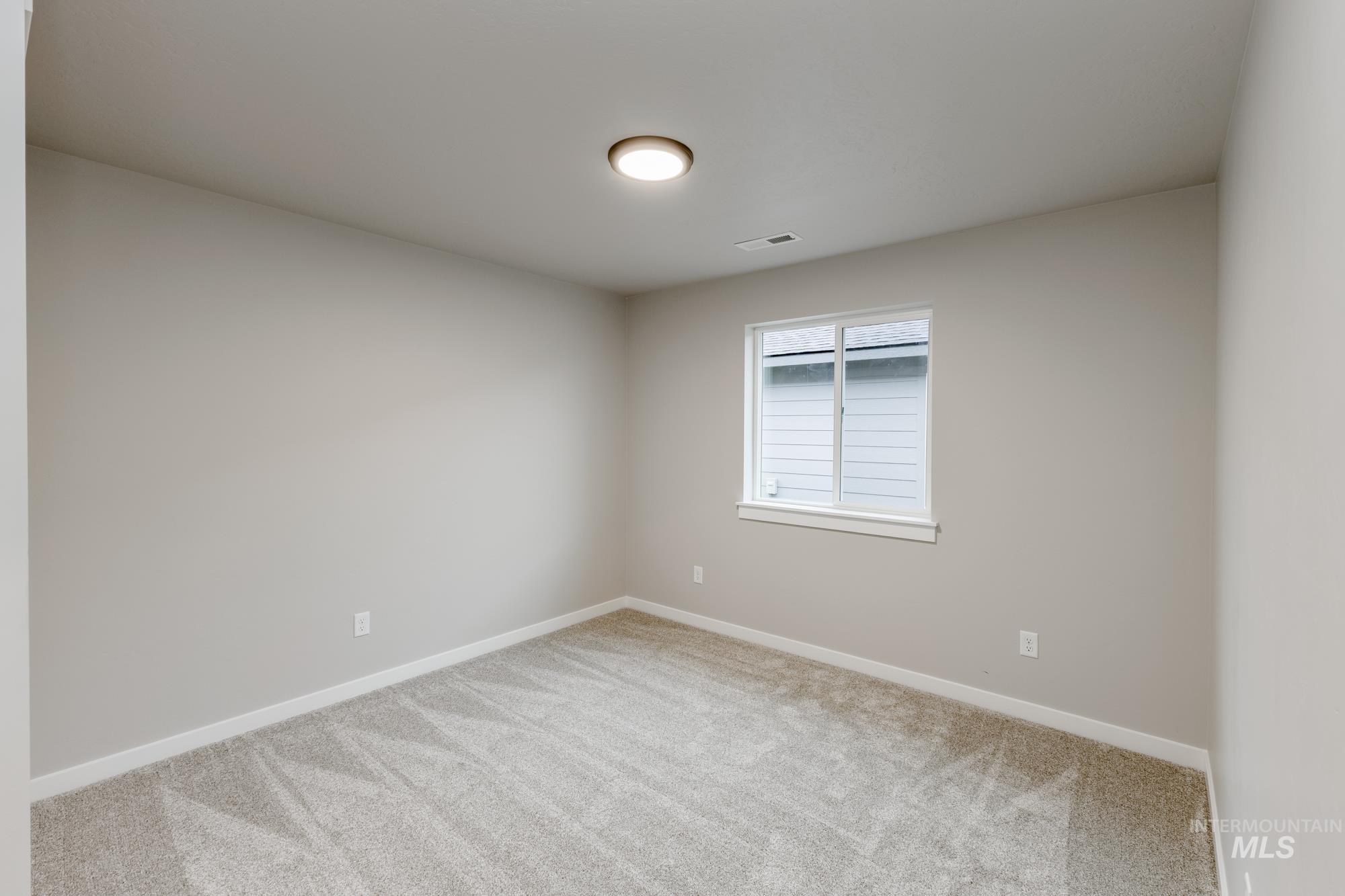 Carpeted empty room featuring baseboards
