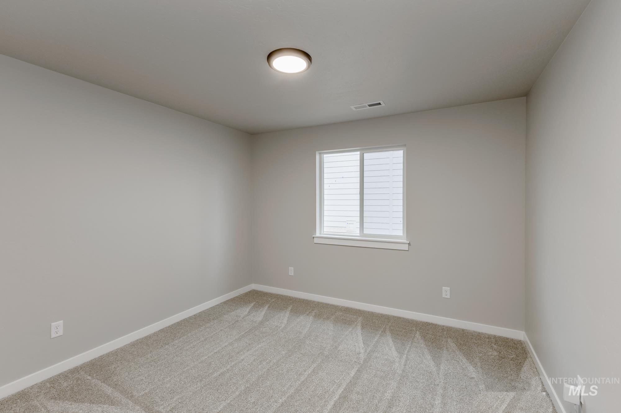 Spare room with baseboards and light carpet