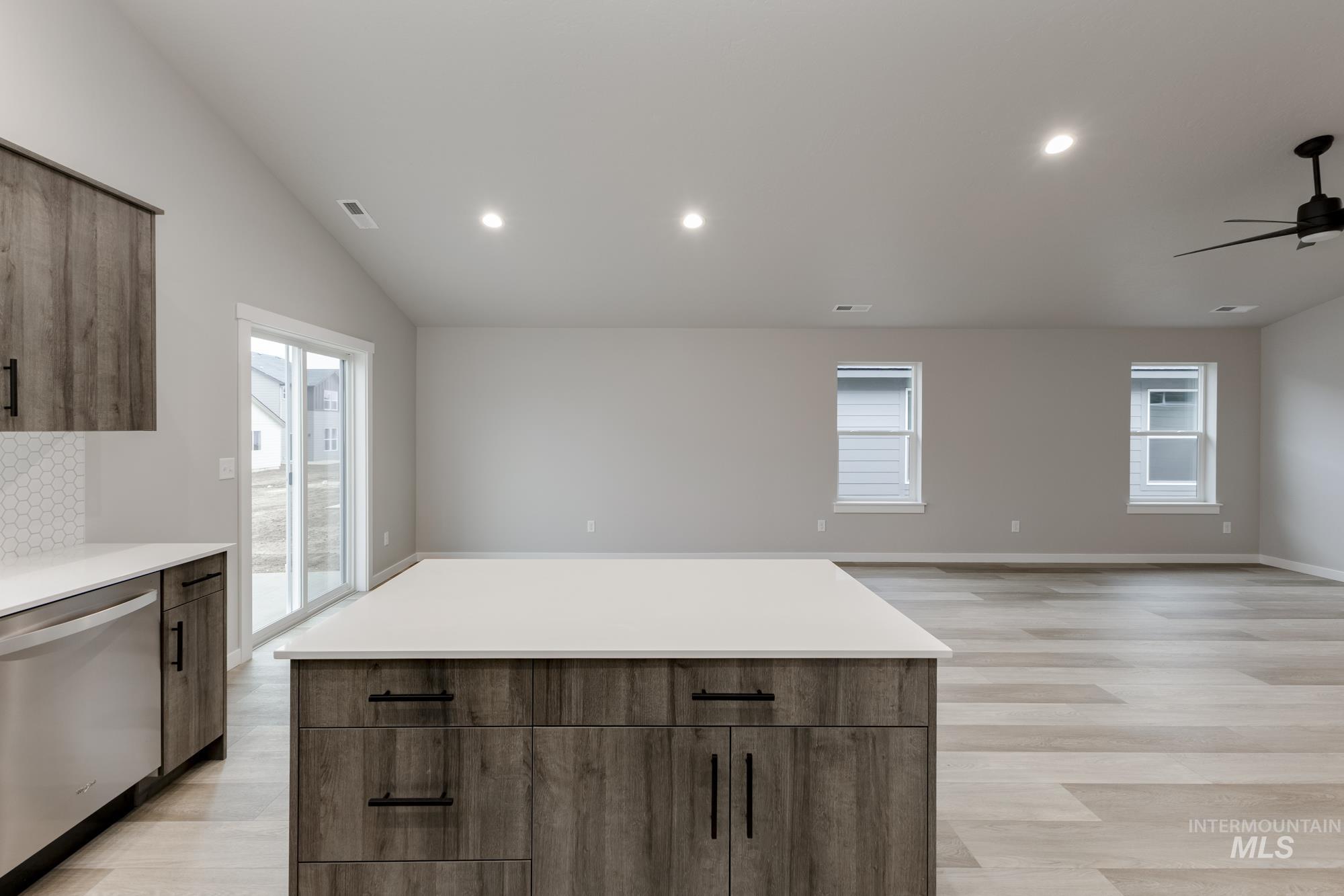 Kitchen with dishwasher, recessed lighting, a ceiling fan, a center island, and lofted ceiling