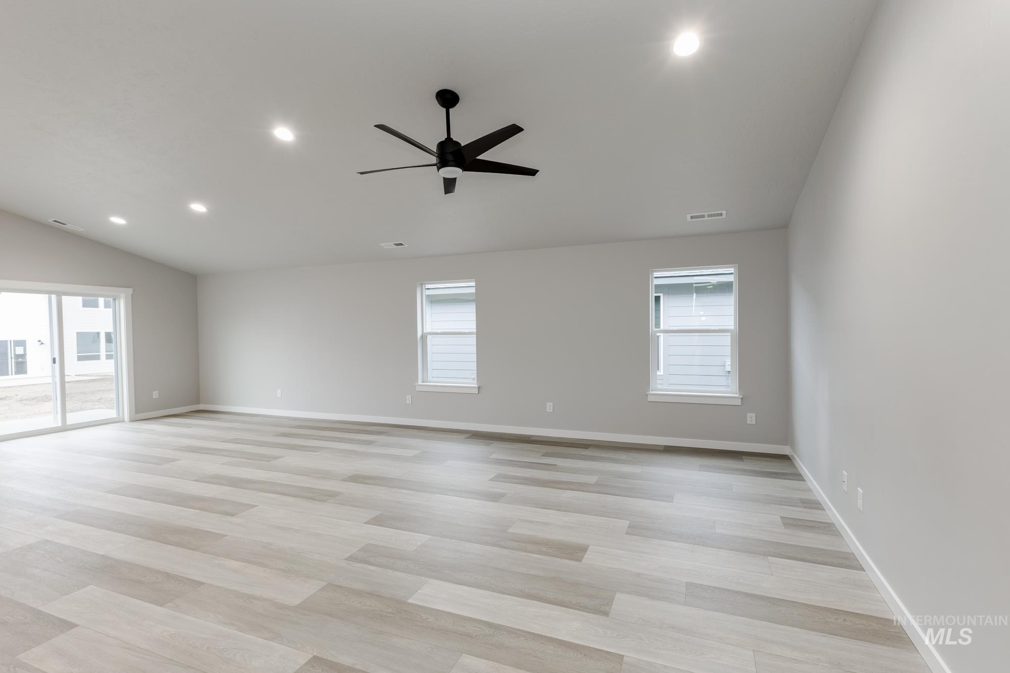 Unfurnished room featuring recessed lighting, healthy amount of natural light, a ceiling fan, light wood-style floors, and vaulted ceiling