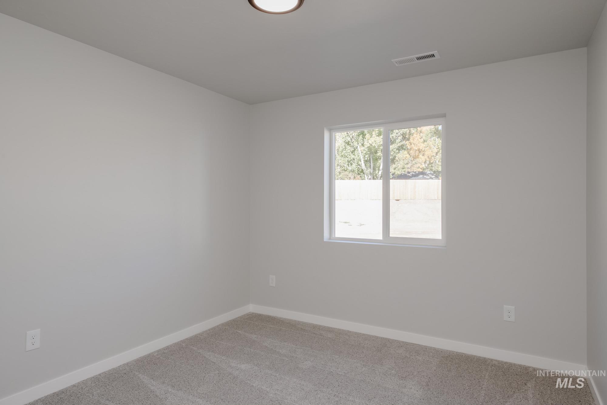 Unfurnished room featuring light colored carpet and baseboards