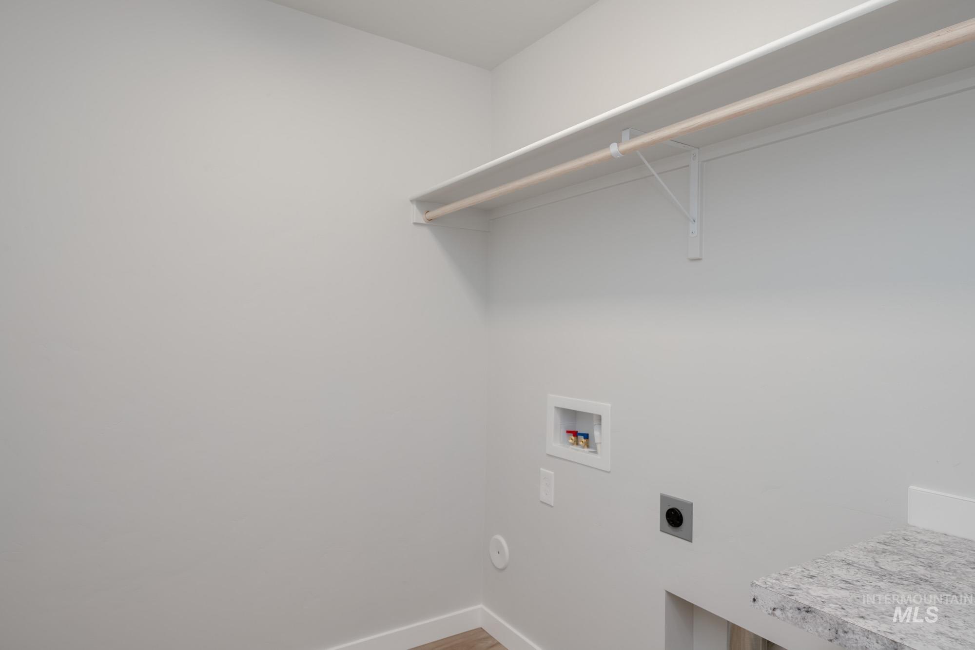 Laundry room featuring hookup for an electric dryer, hookup for a washing machine, and light wood-type flooring
