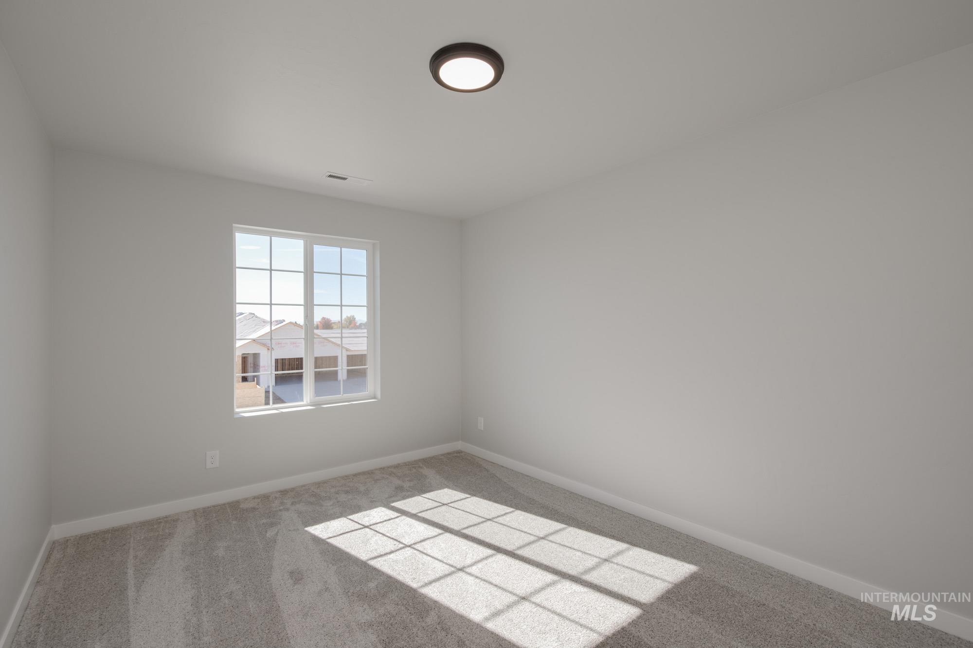 Empty room featuring carpet flooring and baseboards