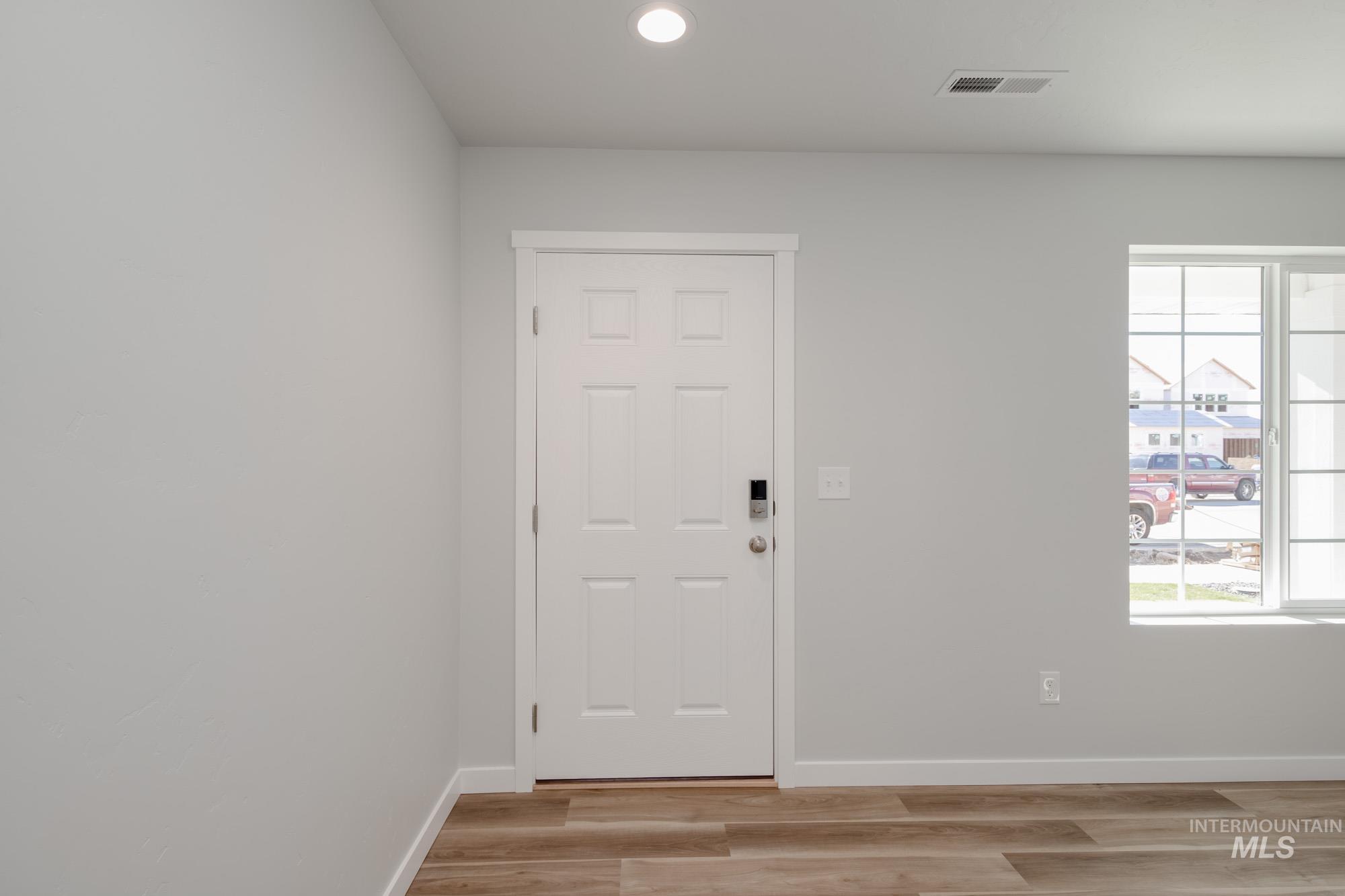 Foyer entrance featuring light wood finished floors and recessed lighting