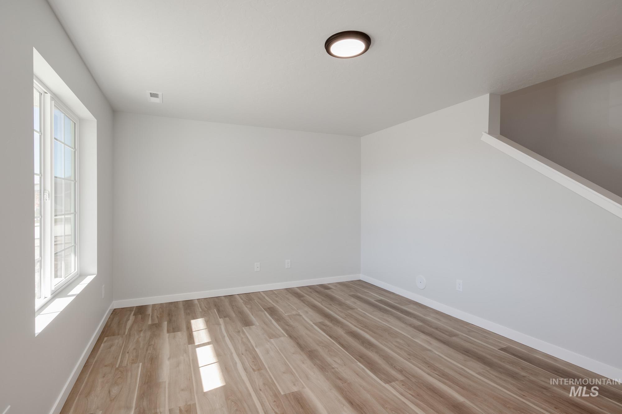 Empty room with light wood finished floors and baseboards