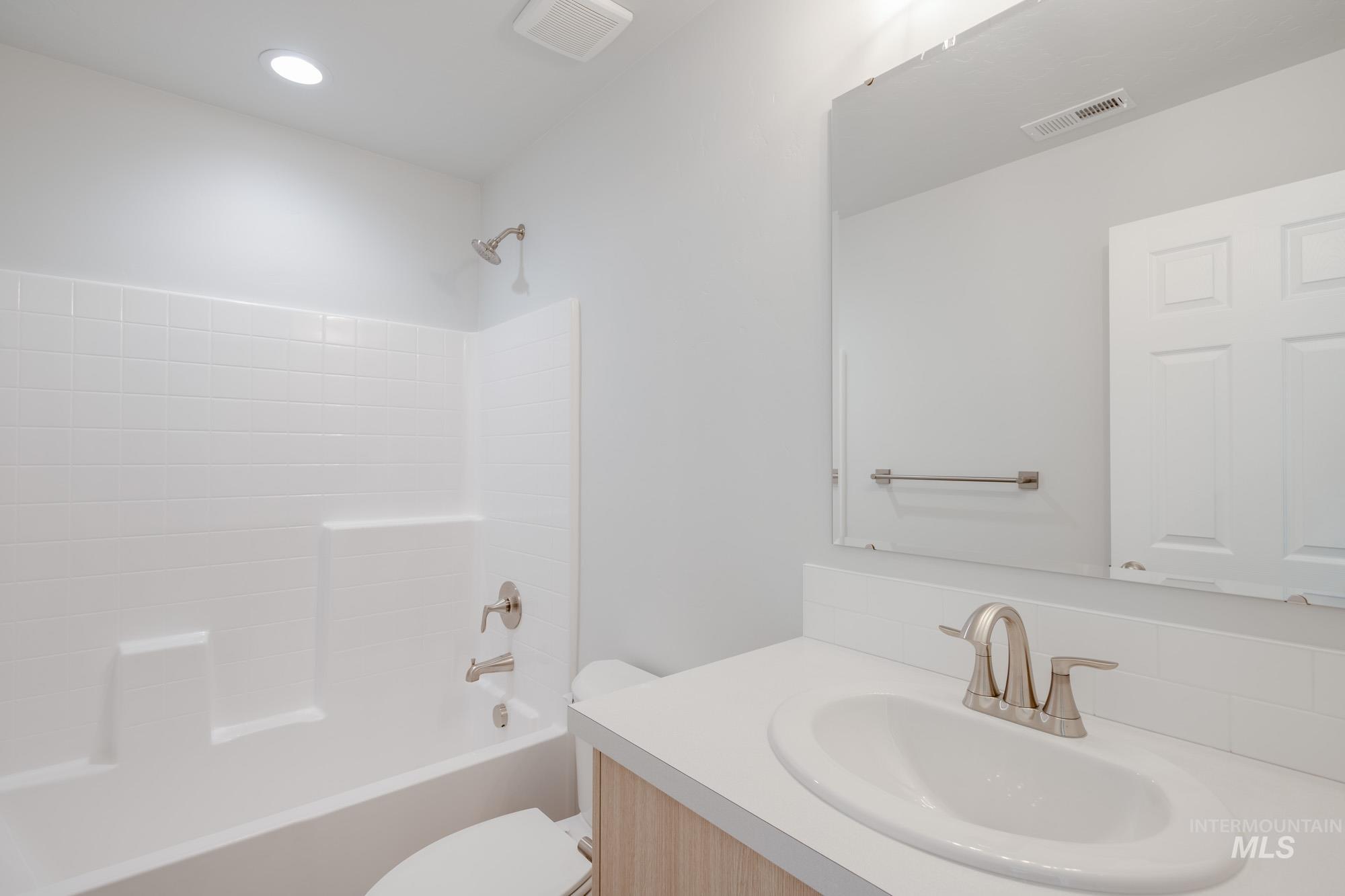 Bathroom with shower / bathtub combination, vanity, and recessed lighting