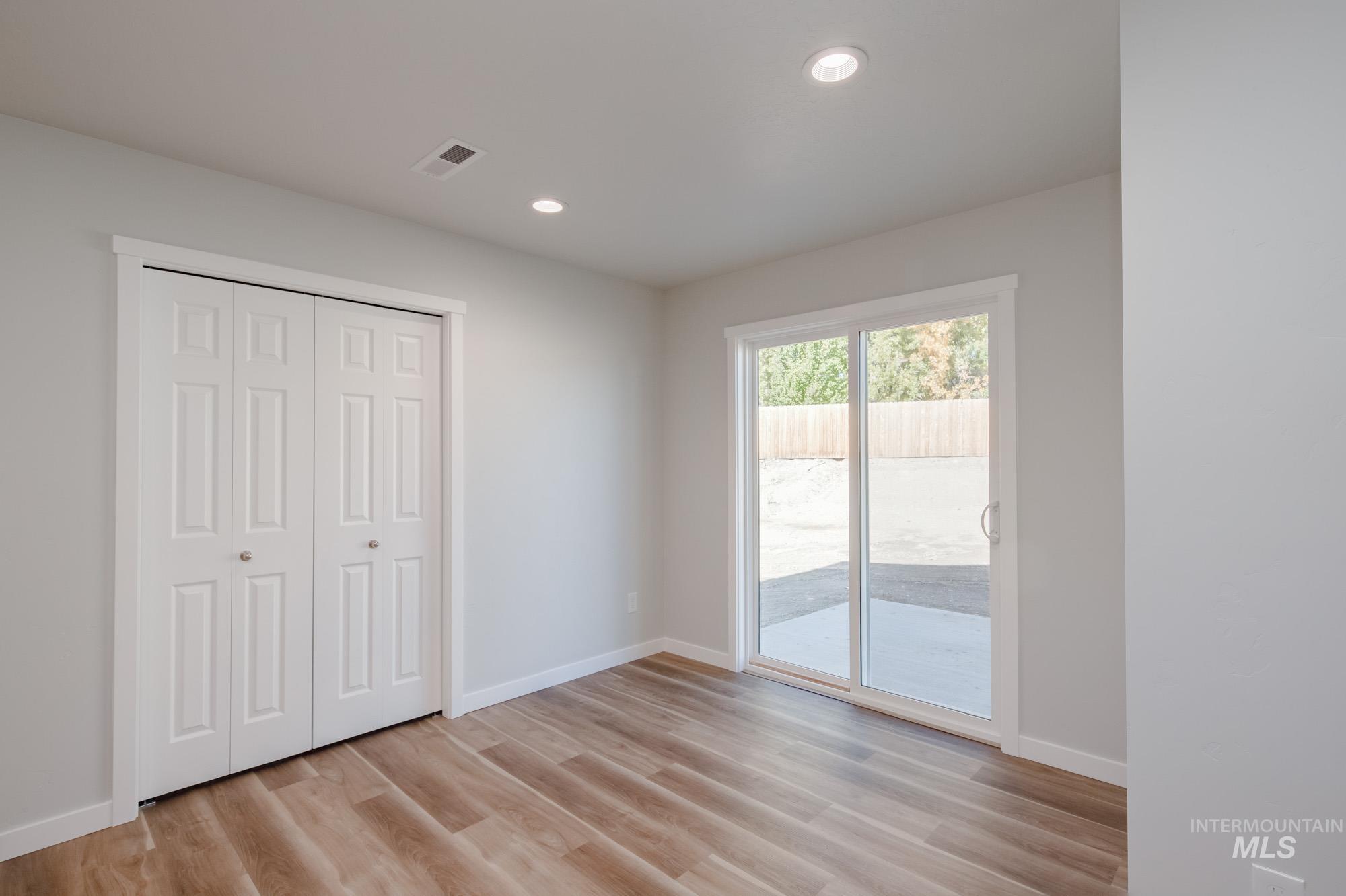 Unfurnished bedroom featuring access to outside, light wood-style flooring, a closet, and recessed lighting