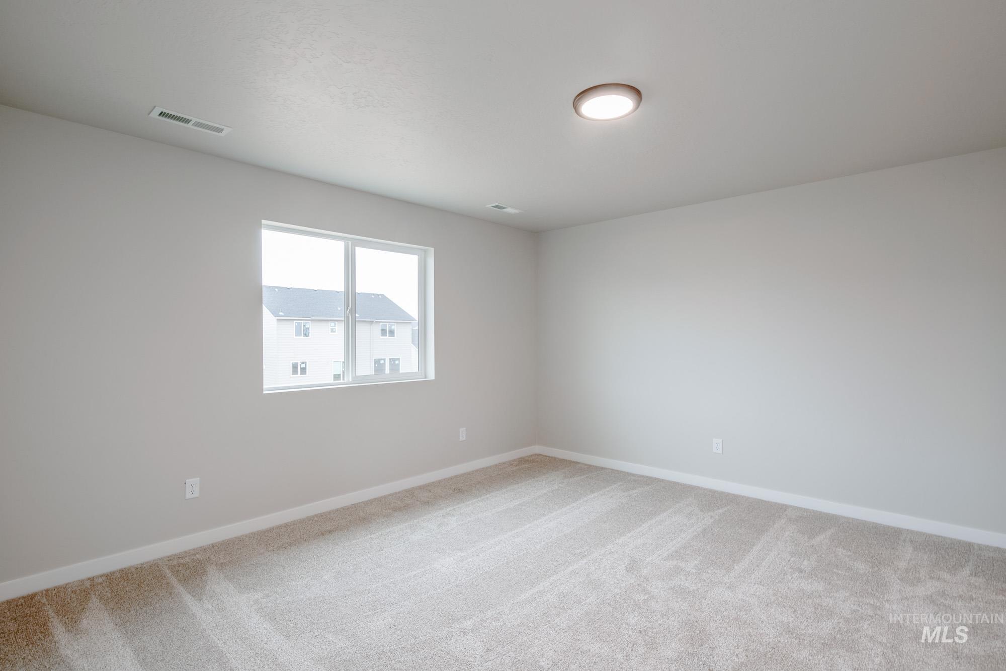 Empty room with light carpet and baseboards