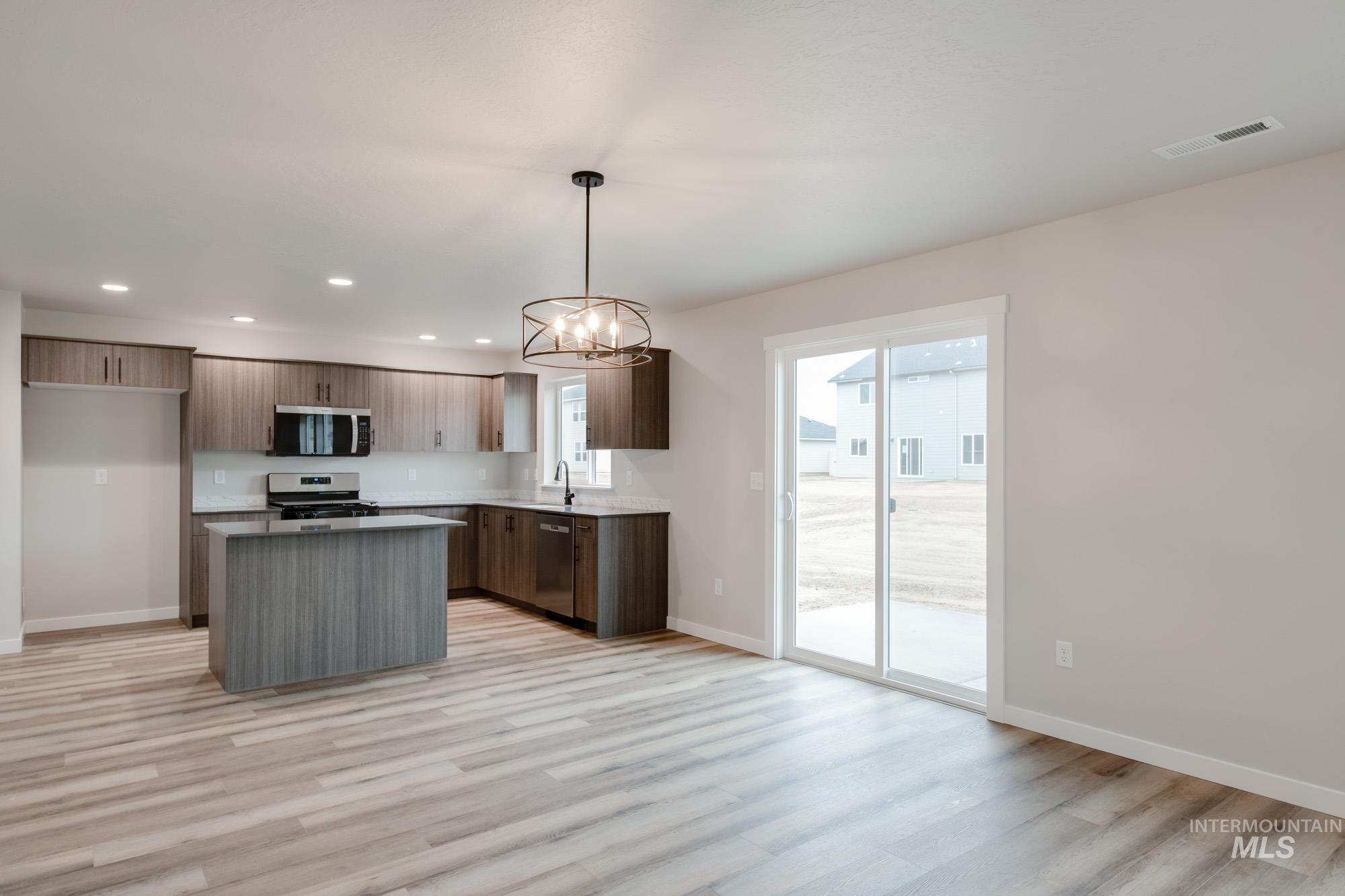 Kitchen with a center island, recessed lighting, stainless steel appliances, hanging light fixtures, and a chandelier
