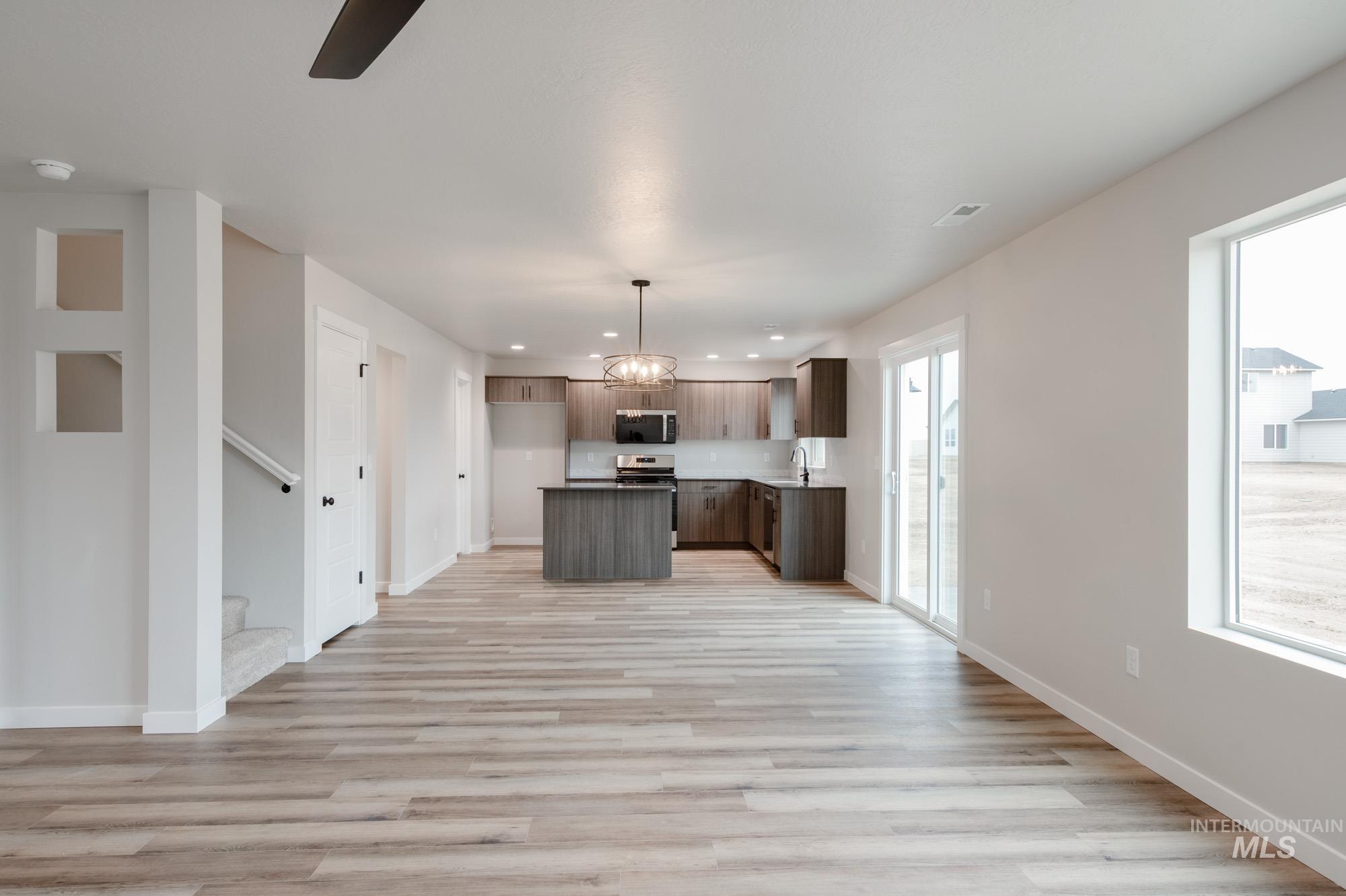 Kitchen featuring open floor plan, light wood-type flooring, a center island, hanging light fixtures, and recessed lighting