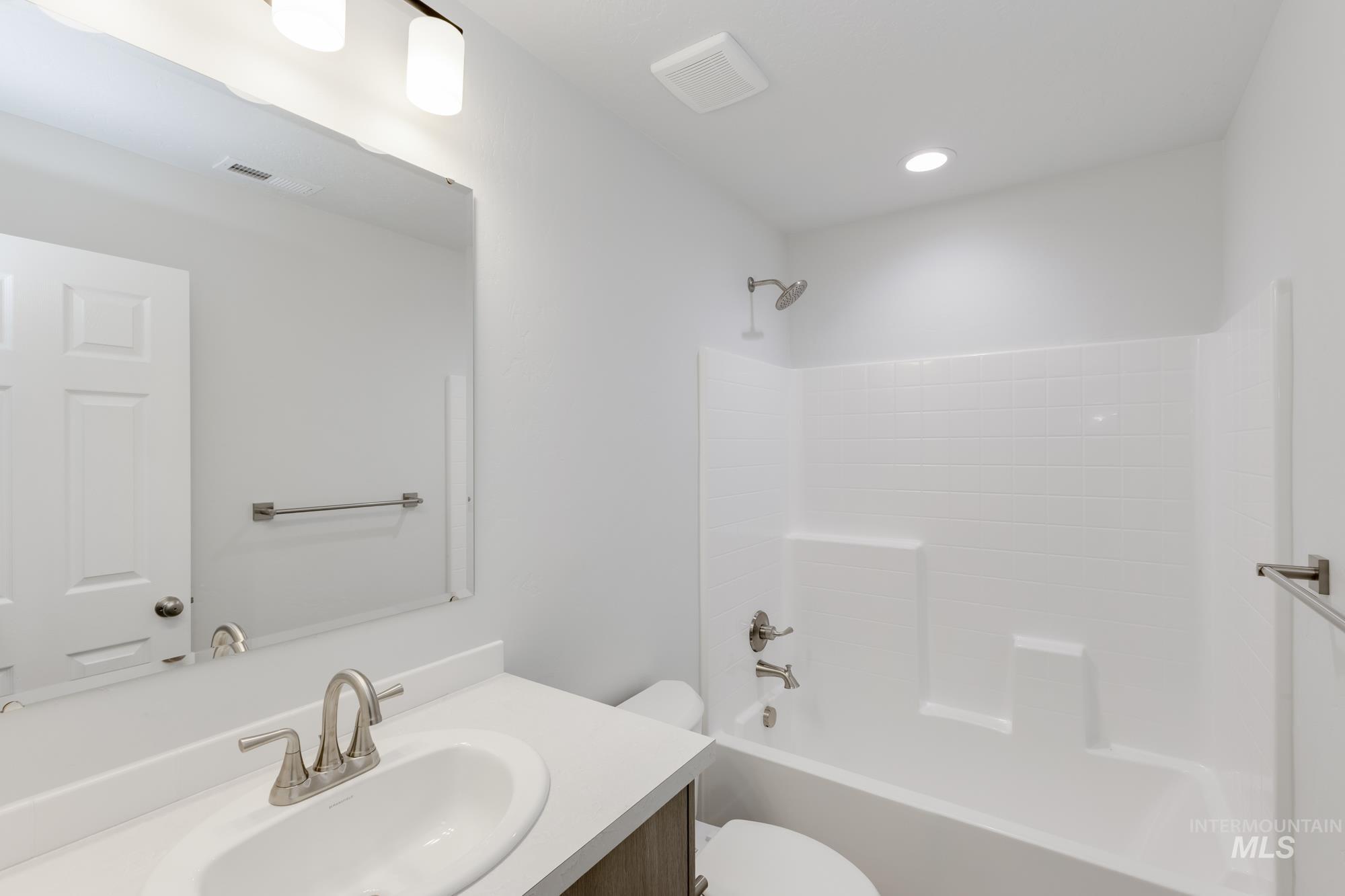 Bathroom featuring vanity, tub / shower combination, and recessed lighting
