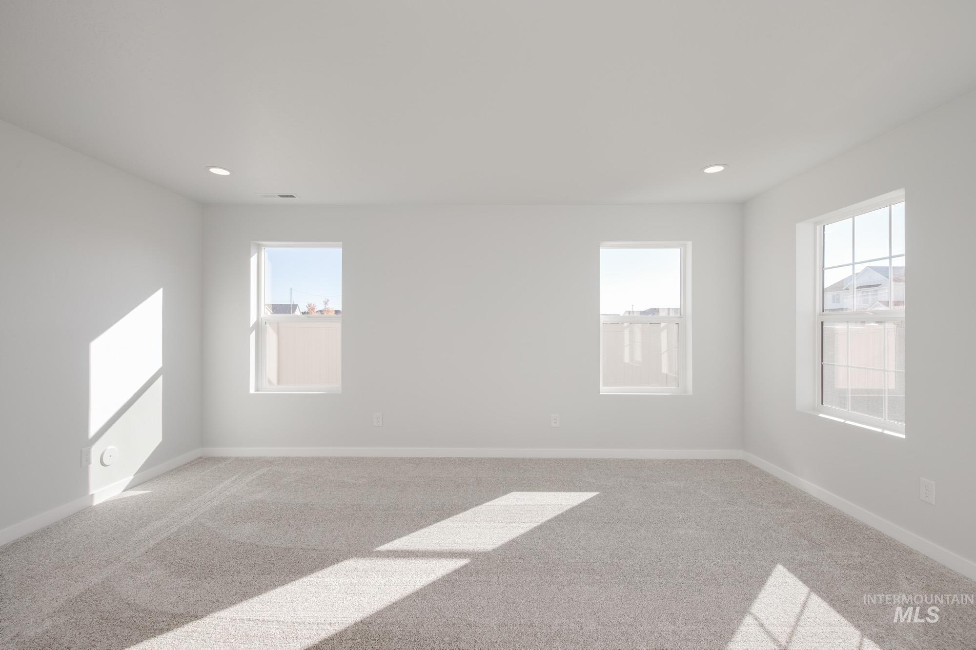 Carpeted empty room with baseboards and recessed lighting