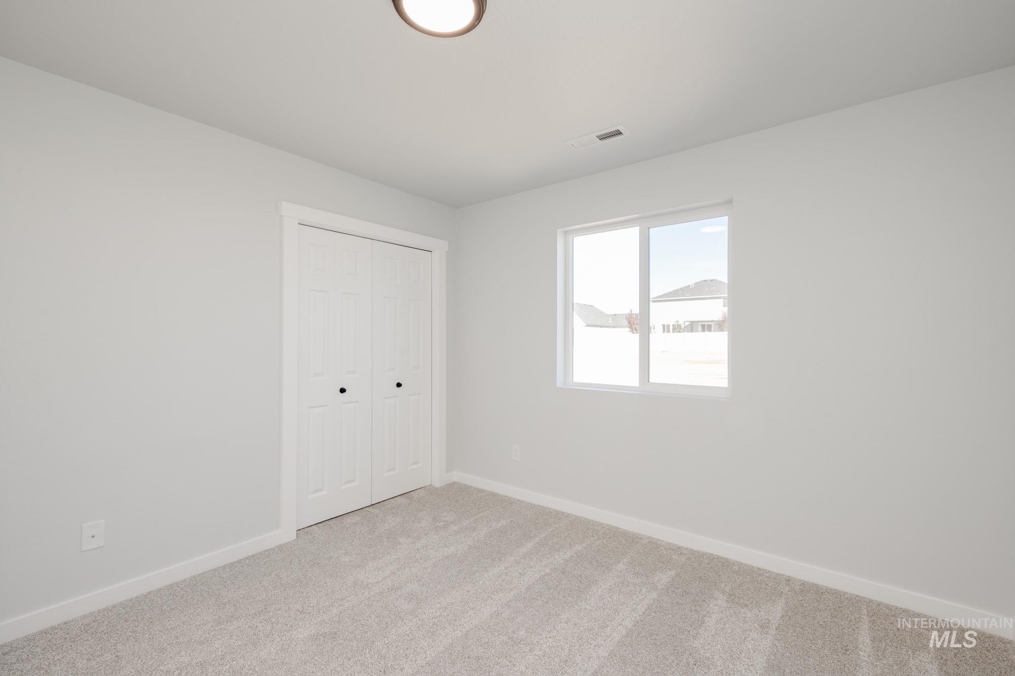 Unfurnished bedroom featuring carpet flooring and a closet