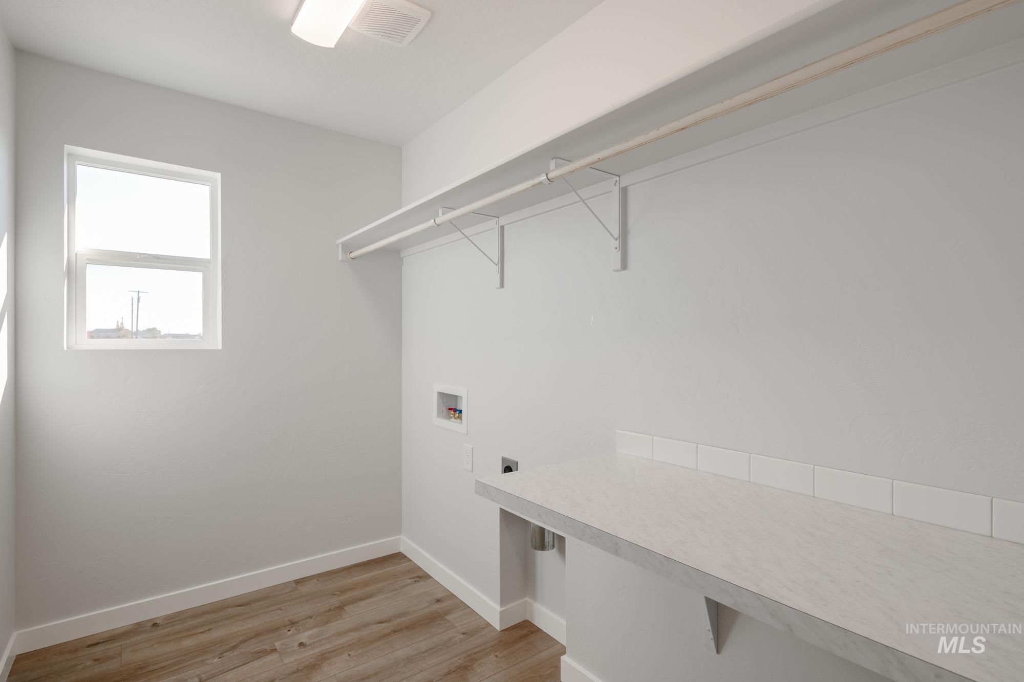 Washroom featuring light wood-type flooring, washer hookup, and hookup for an electric dryer