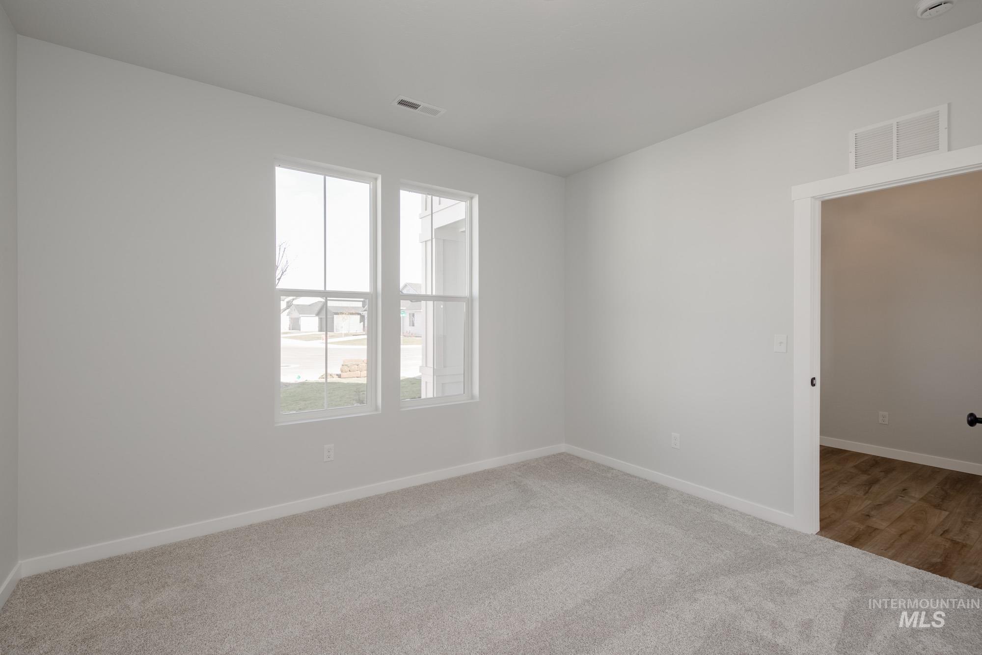 Spare room featuring light carpet and baseboards