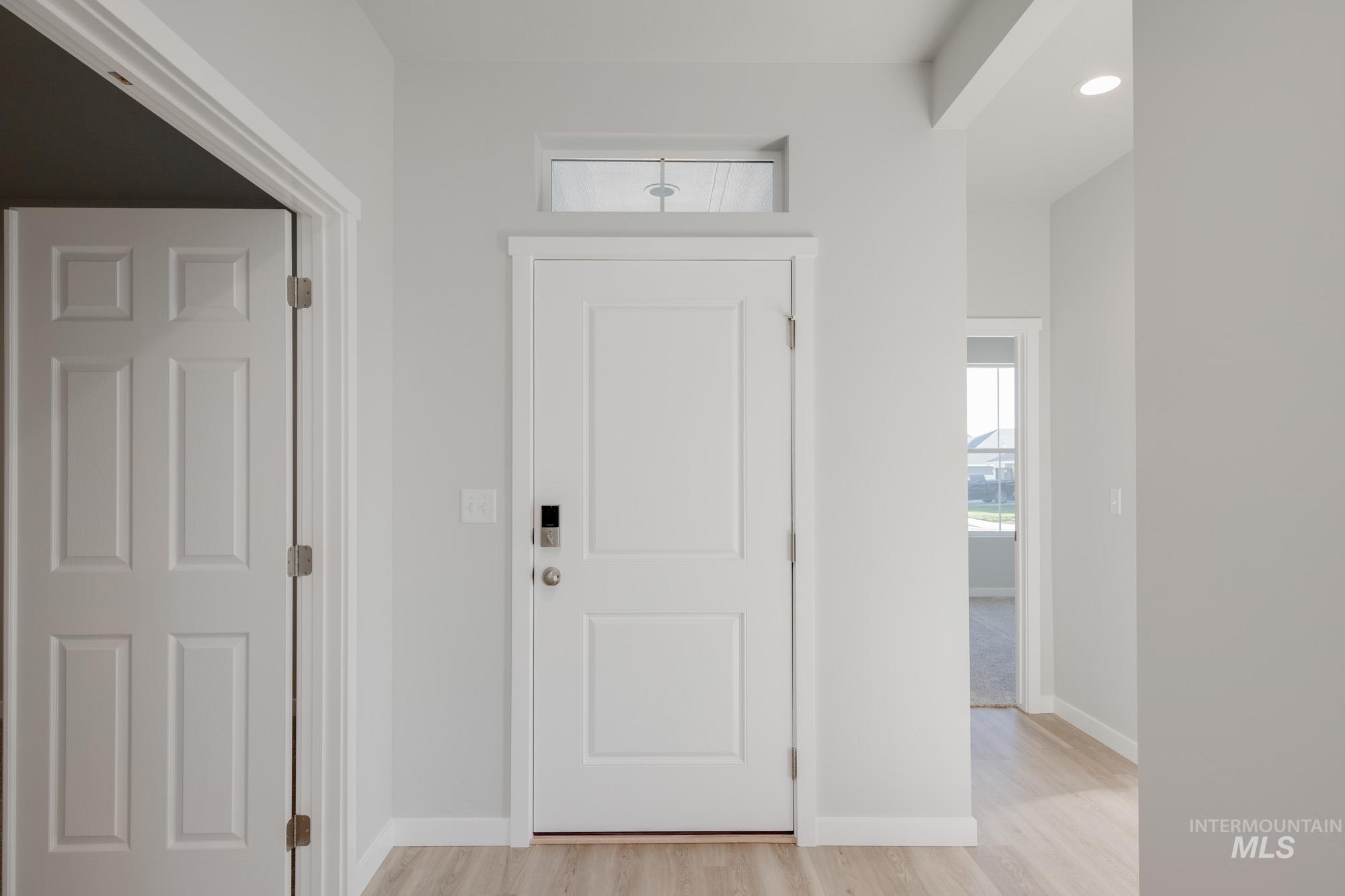 Foyer featuring light wood-style flooring and baseboards