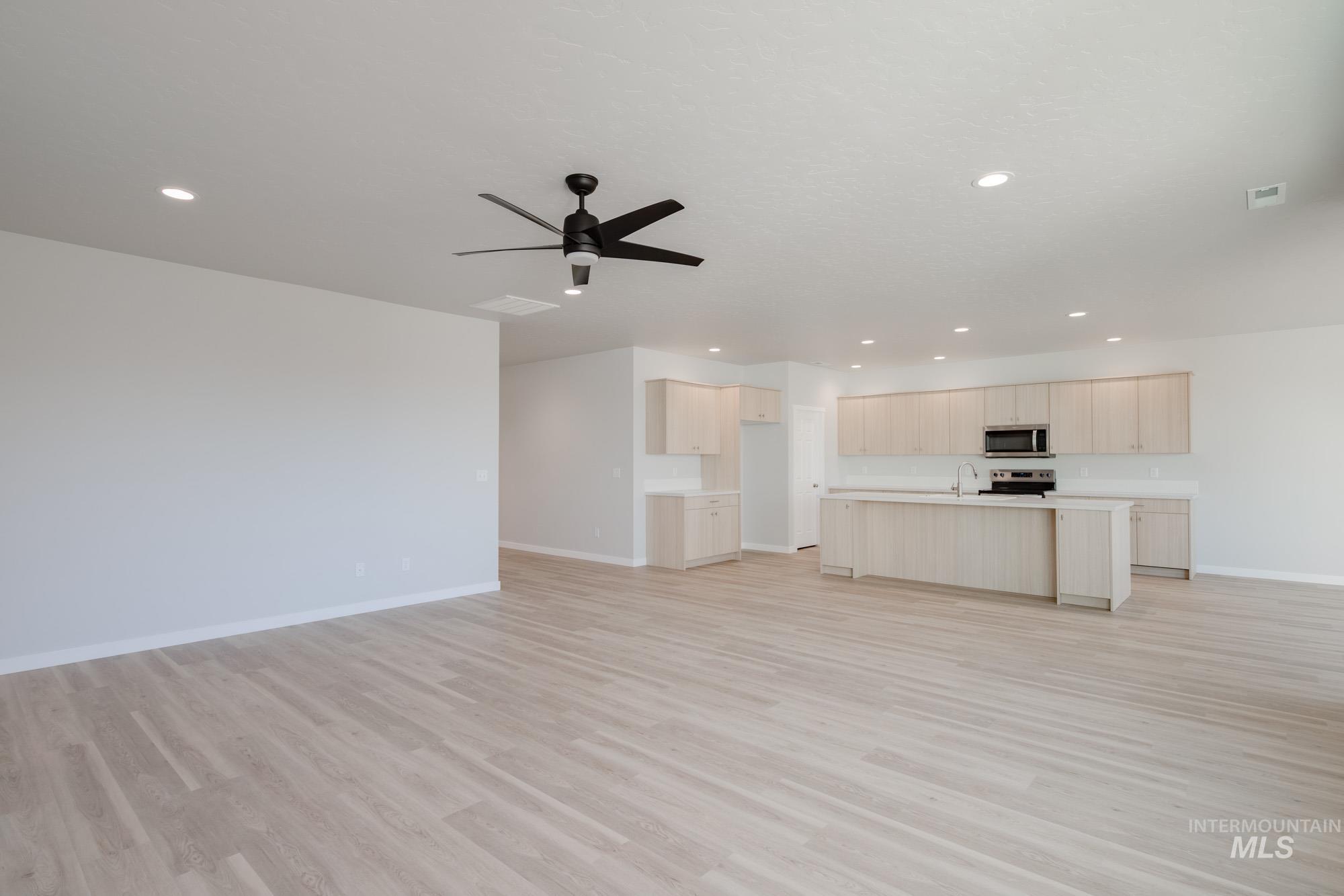 Unfurnished living room featuring recessed lighting, ceiling fan, and light wood finished floors