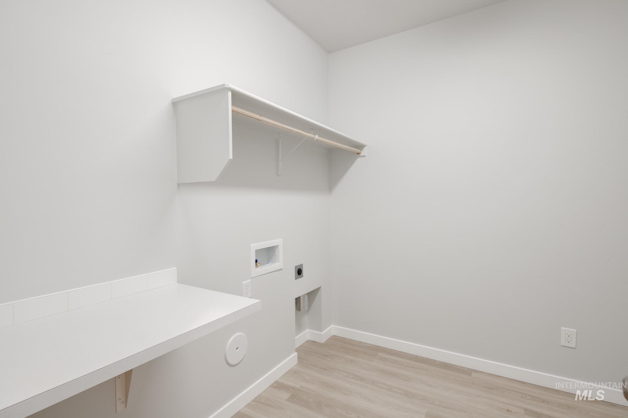 Washroom featuring hookup for a washing machine, light wood-type flooring, and hookup for an electric dryer