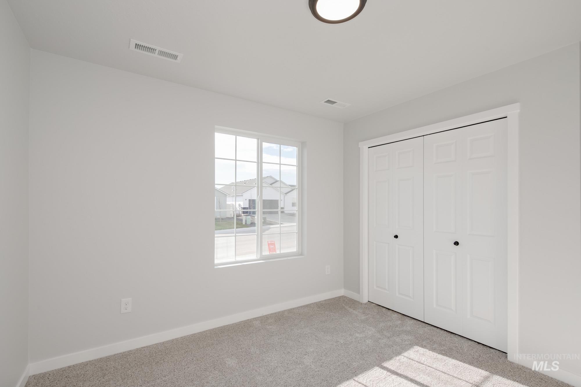 Unfurnished bedroom with a closet and light colored carpet