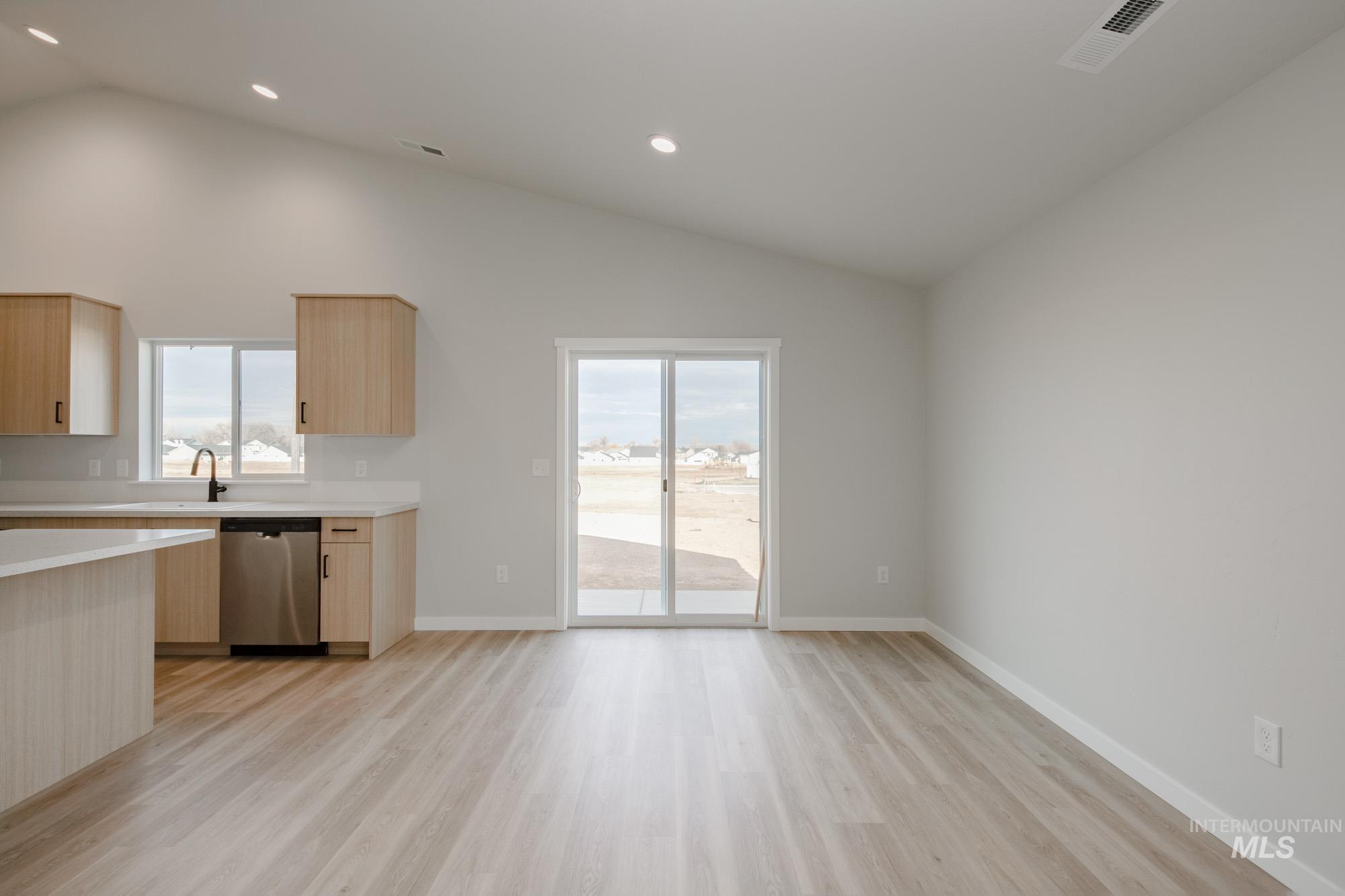 Kitchen with light brown cabinets, light wood-style floors, stainless steel dishwasher, modern cabinets, and recessed lighting